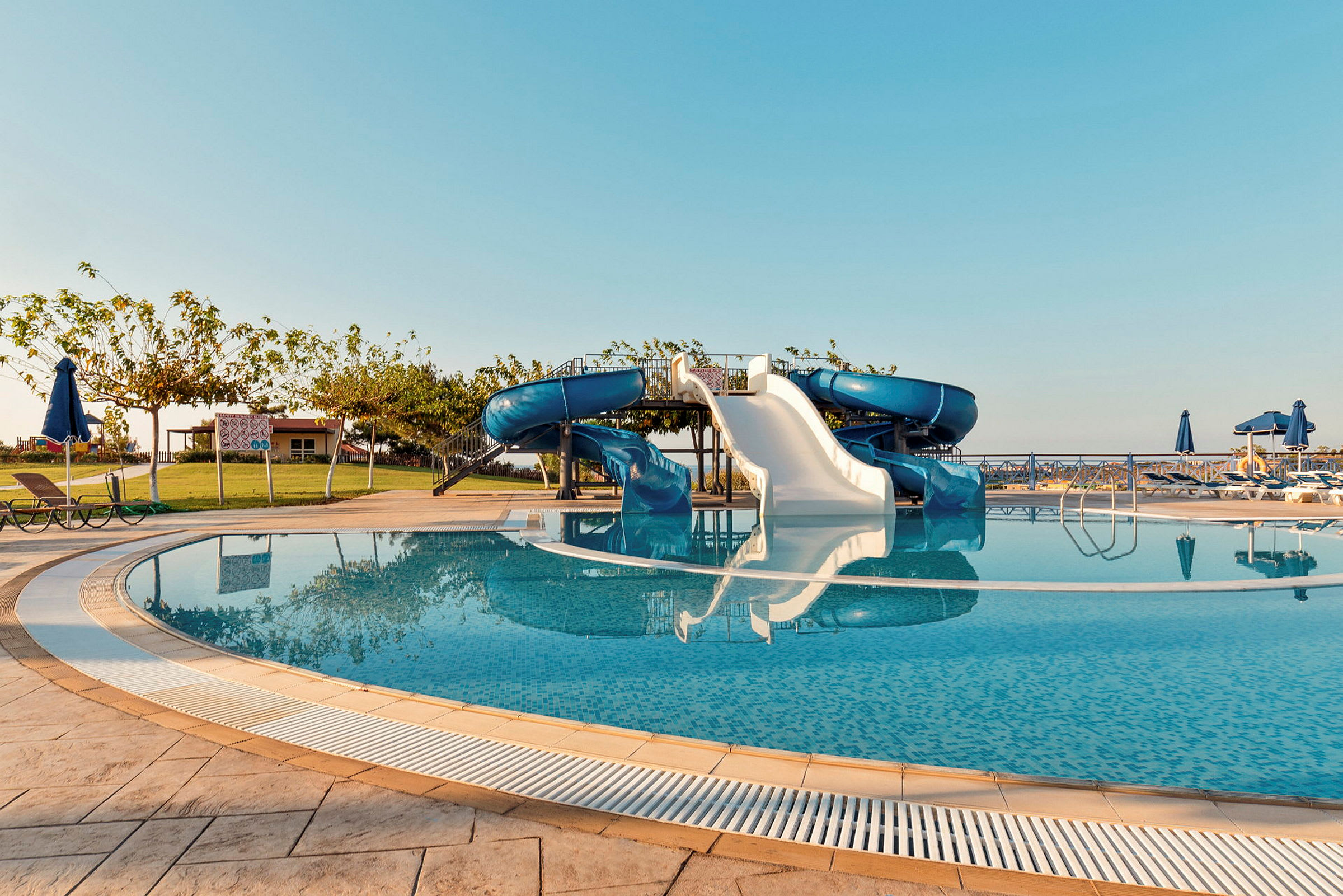 Pool med vandrutsjebaner under klar himmel. (AI-genereret tekst)