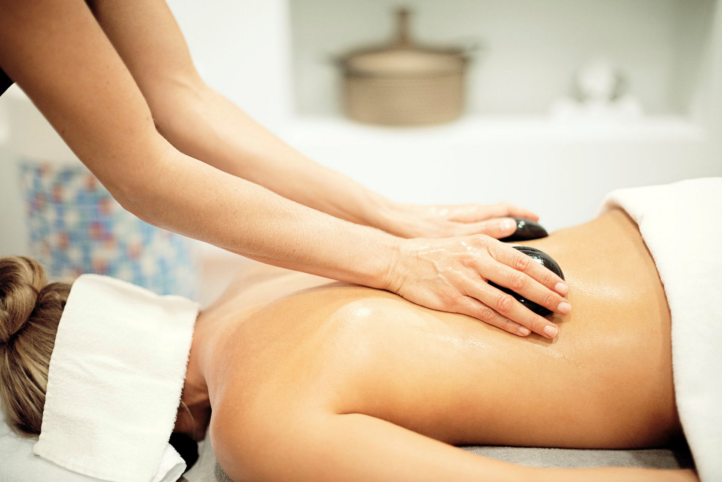 Person får en massage med varme sten på ryggen. (AI-genereret tekst)