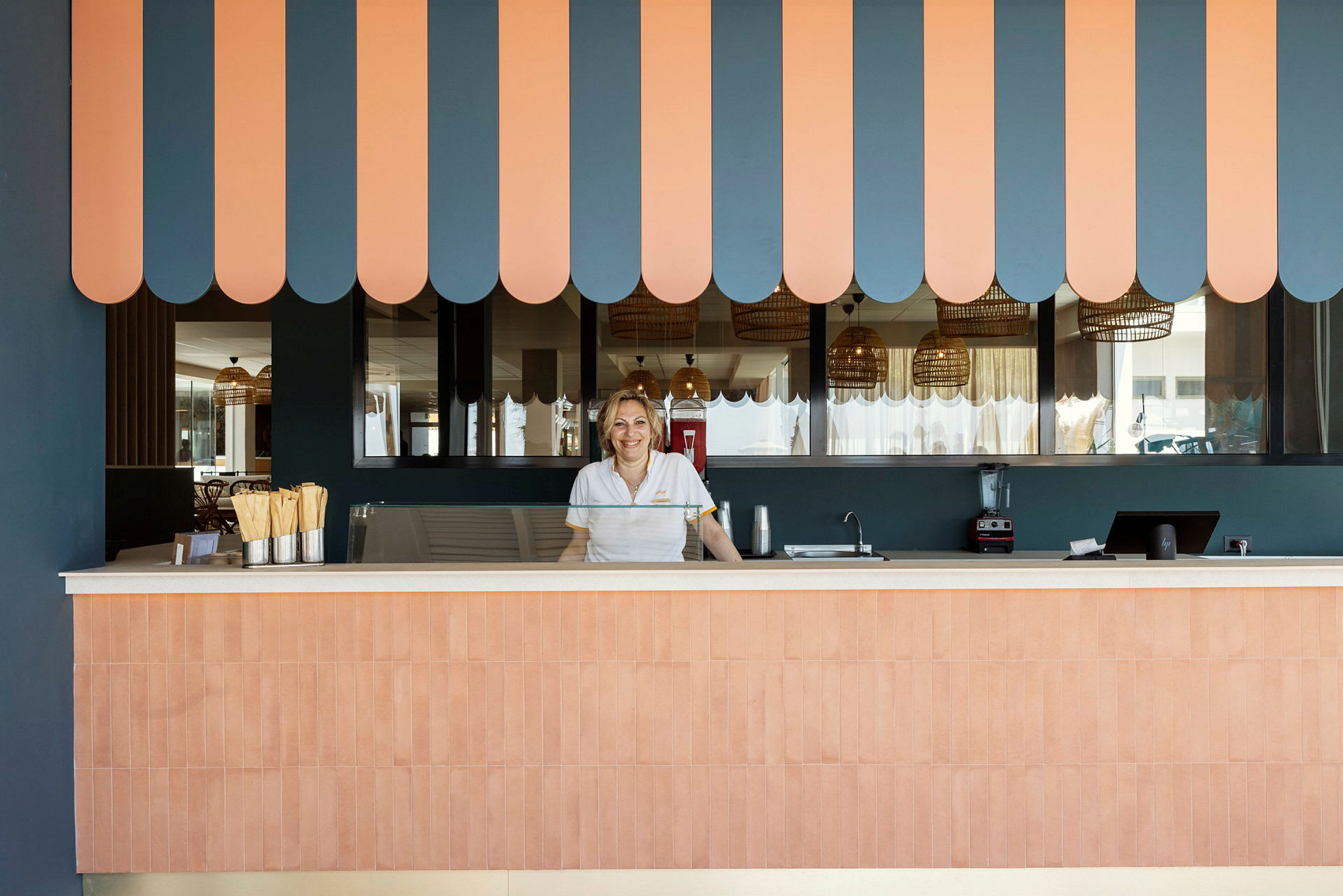 Reception med en stribet orange og blå baldakin samt detaljer i træ. (AI-genereret tekst)