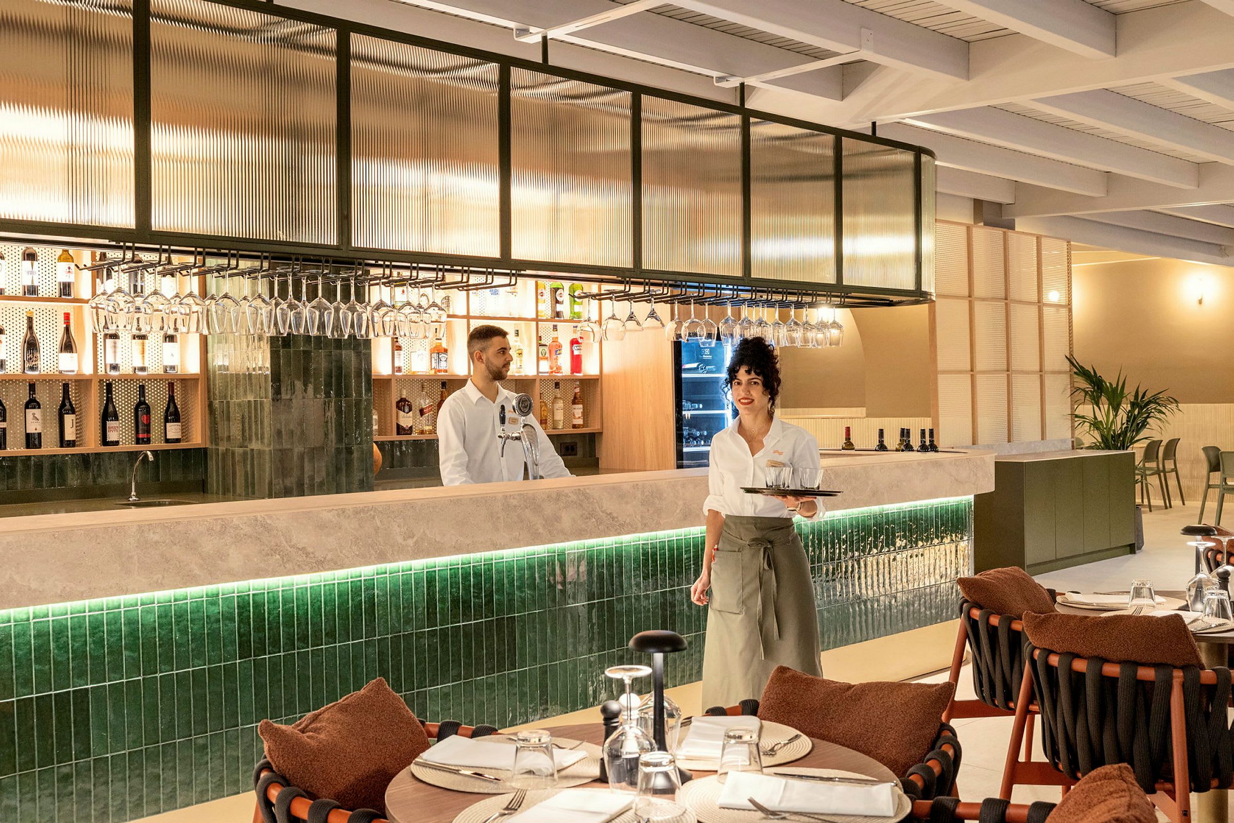 En restaurantinteriør med en bardisk og dækkede borde. (AI-genereret tekst)