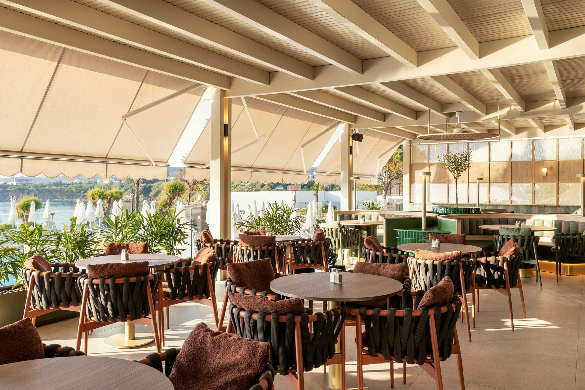 Restaurant med siddepladser ved vinduet og udsigt over vand. (AI-genereret tekst)