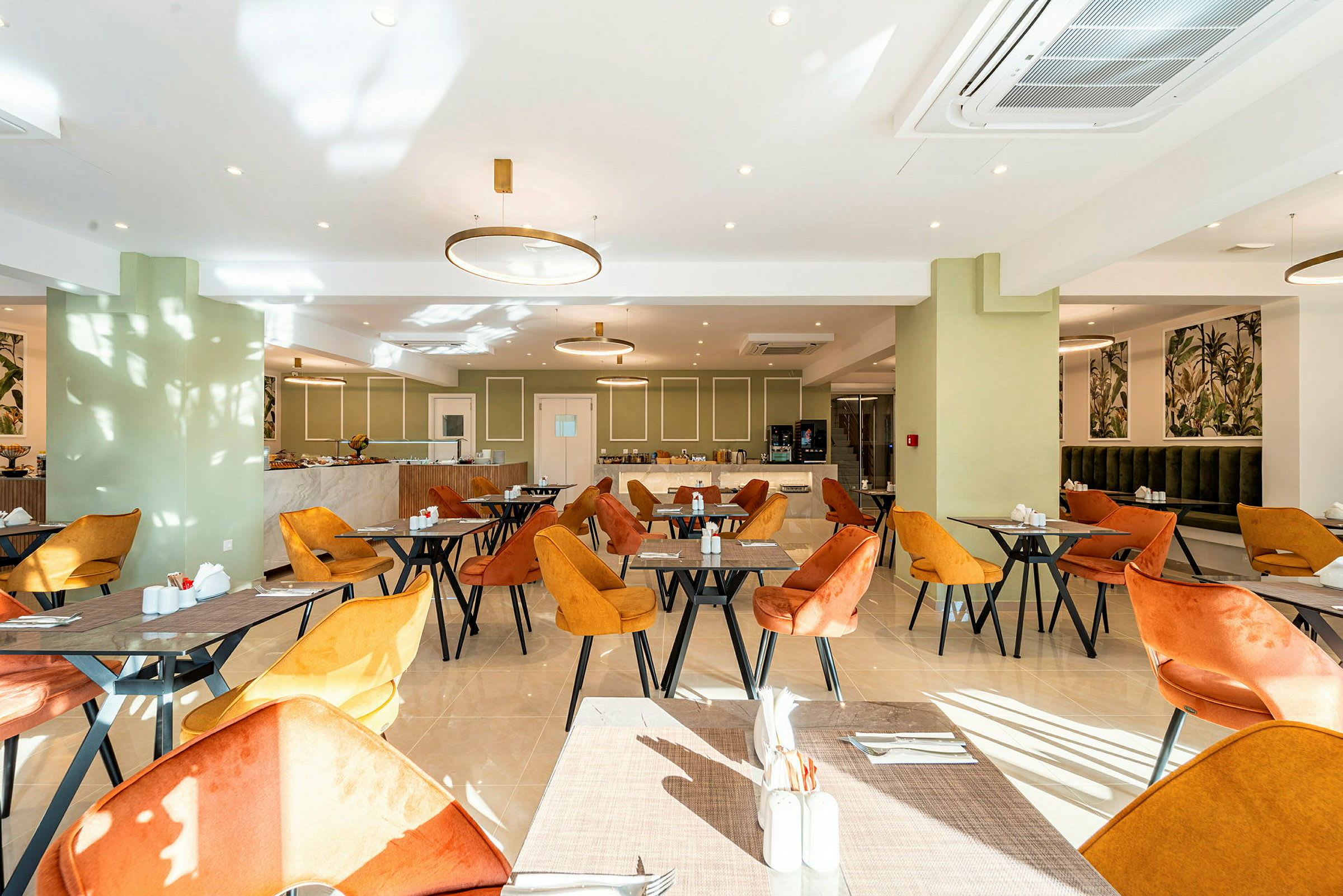 En lys restaurant med orange og gule stole samt borde. (AI-genereret tekst)
