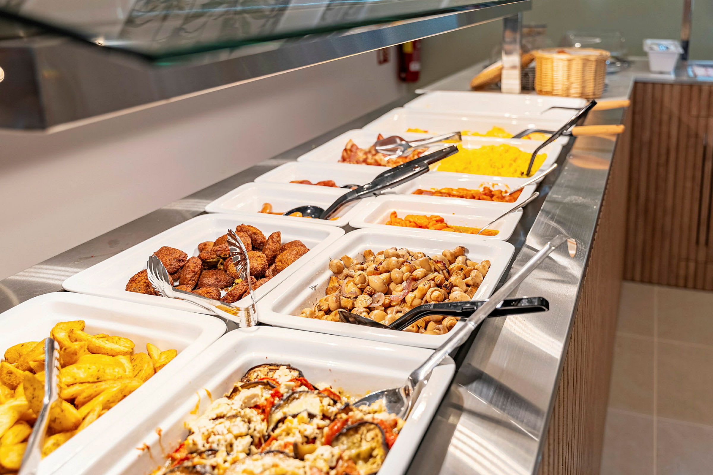 Buffet med forskellige retter, herunder kartofler, falafel og grøntsager. (AI-genereret tekst)