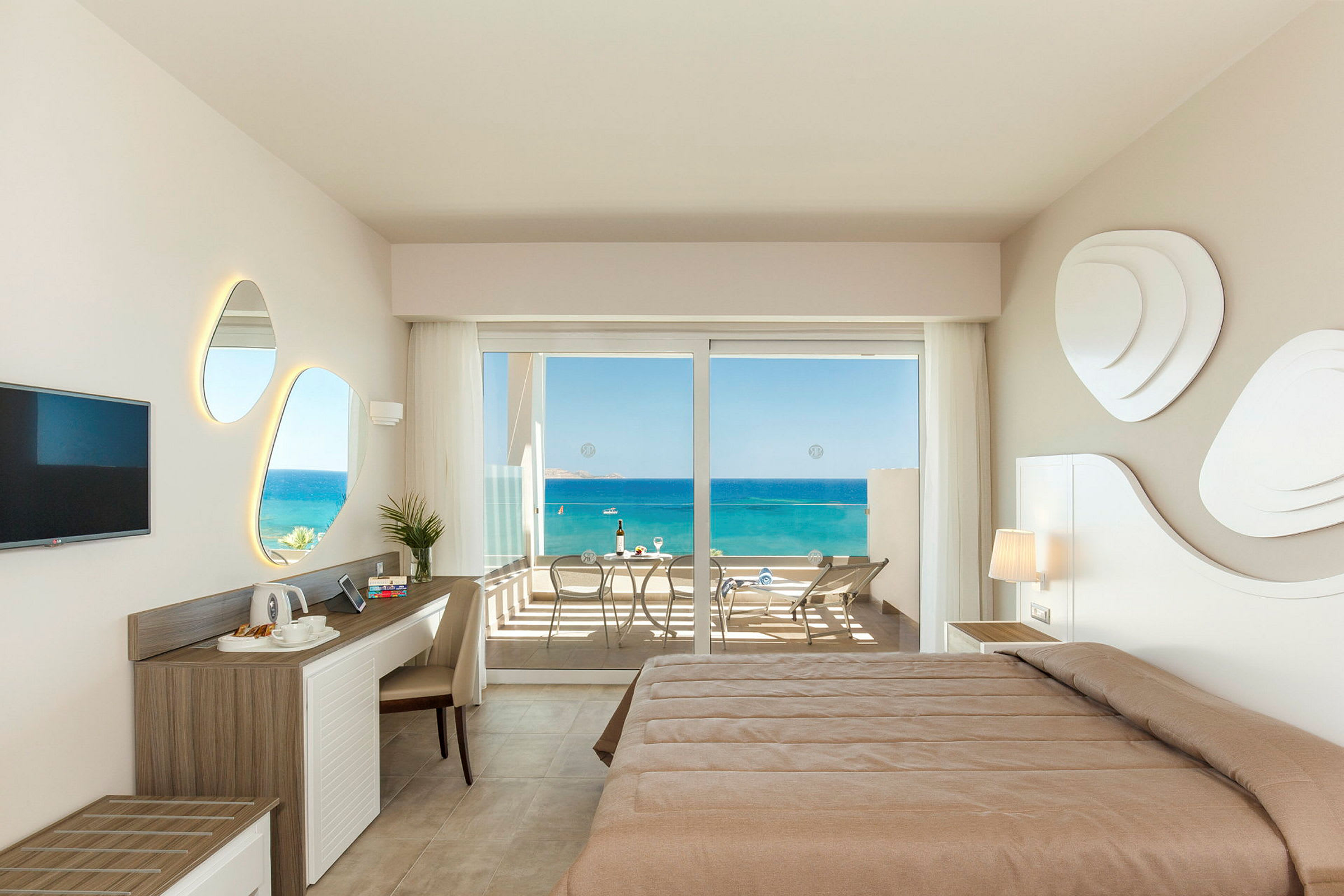 Hotelværelse med udsigt til havet fra en balkon. (AI-genereret tekst)