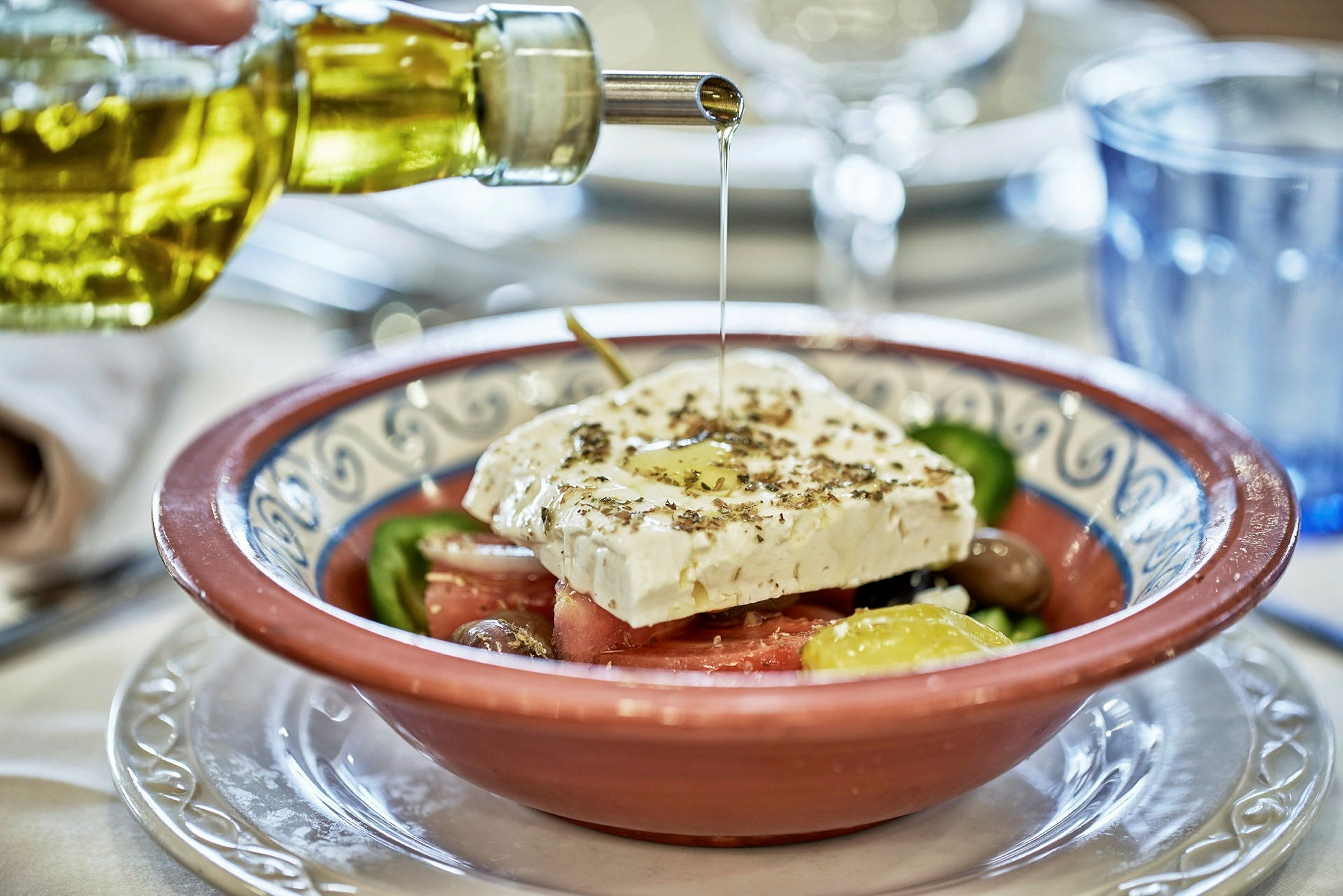 En skål med græsk salat, toppet med fetaost og olivenolie. (AI-genereret tekst)