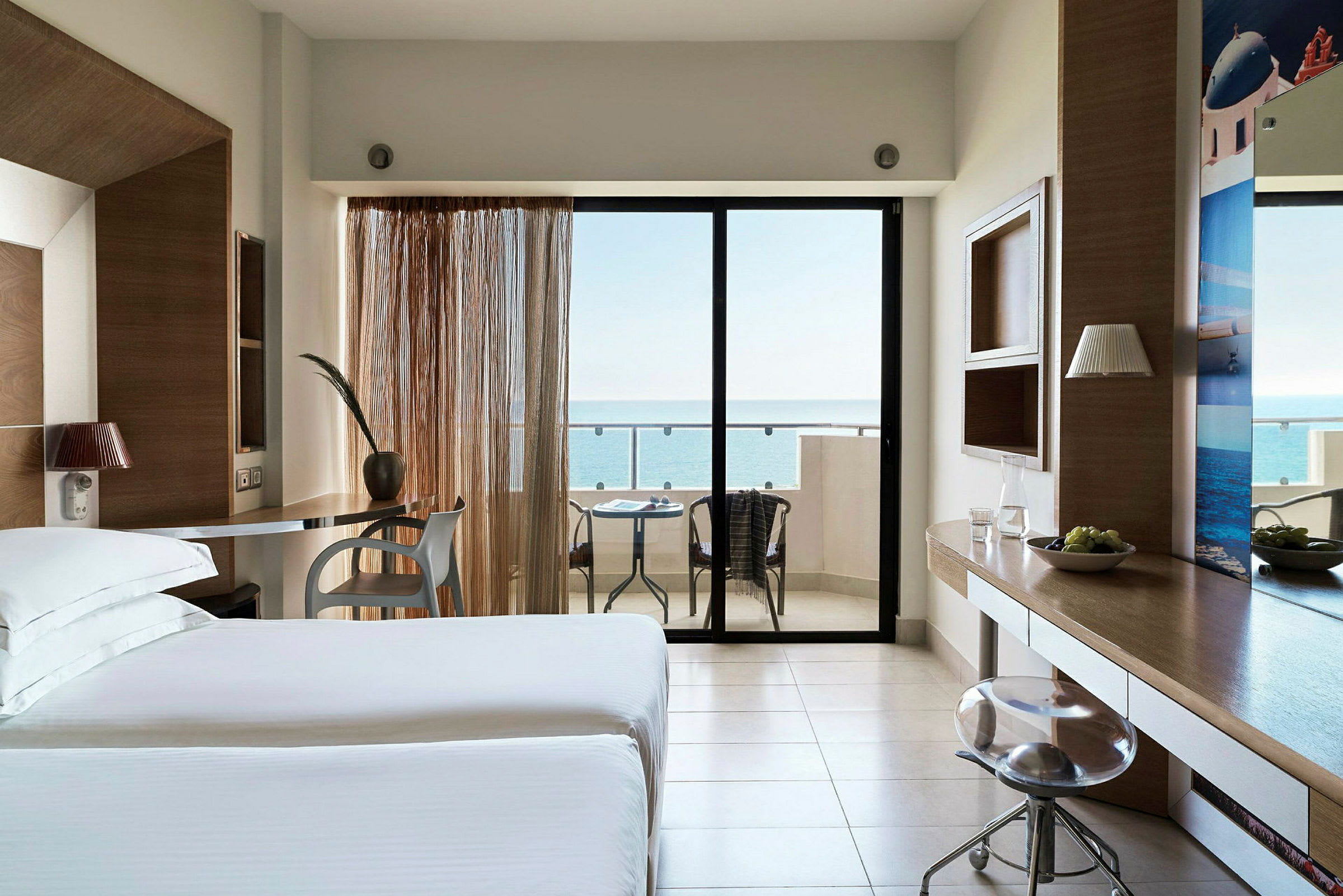 Hotelværelse med moderne indretning, siddeområde og balkon med havudsigt. (AI-genereret tekst)