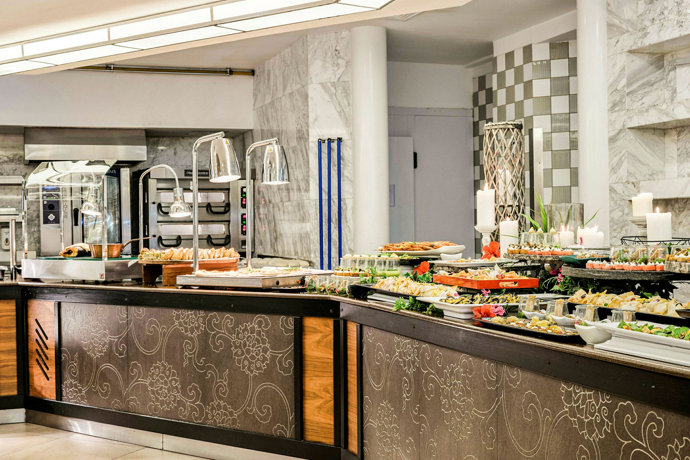 Buffetbord med forskellige retter i en restaurant med marmordetaljer. (AI-genereret tekst)