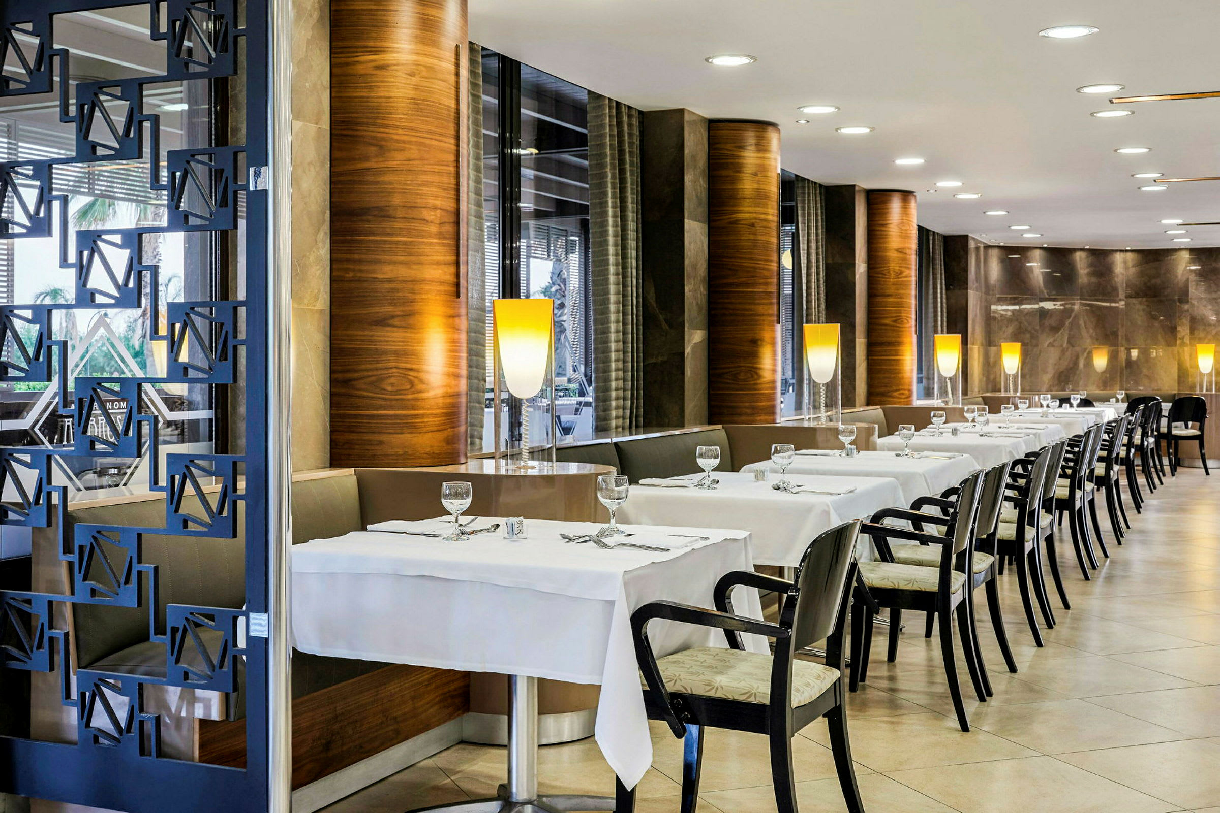 Indretning af en restaurant med dækkede borde og stole. (AI-genereret tekst)