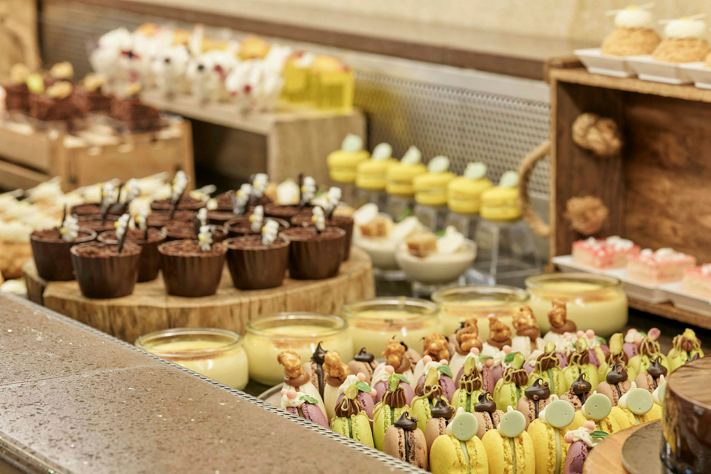 En opstilling af forskellige desserter, inklusive macarons, chokolade- og vaniljedesserter. (AI-genereret tekst)