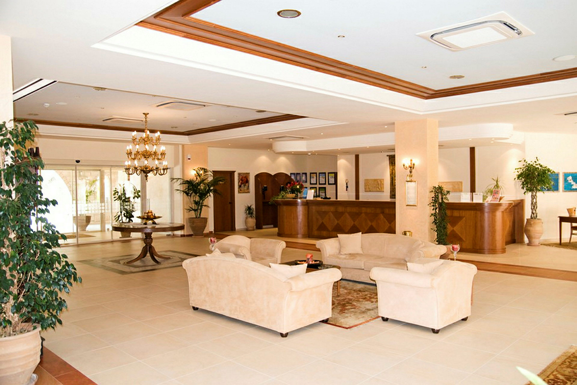 En elegant hotellobby med komfortable sofaer i siddegruppen, en elegant lysekrone og receptionen i baggrunden. (AI-genereret tekst)