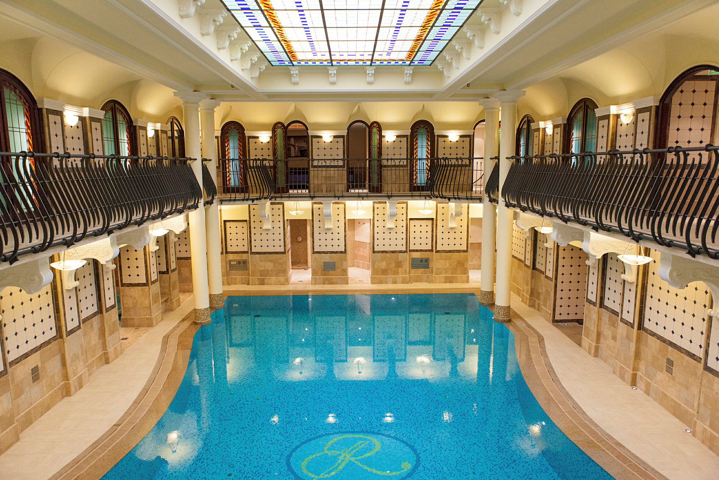Indendørs swimmingpool med omgivende arkitektur. (AI-genereret tekst)