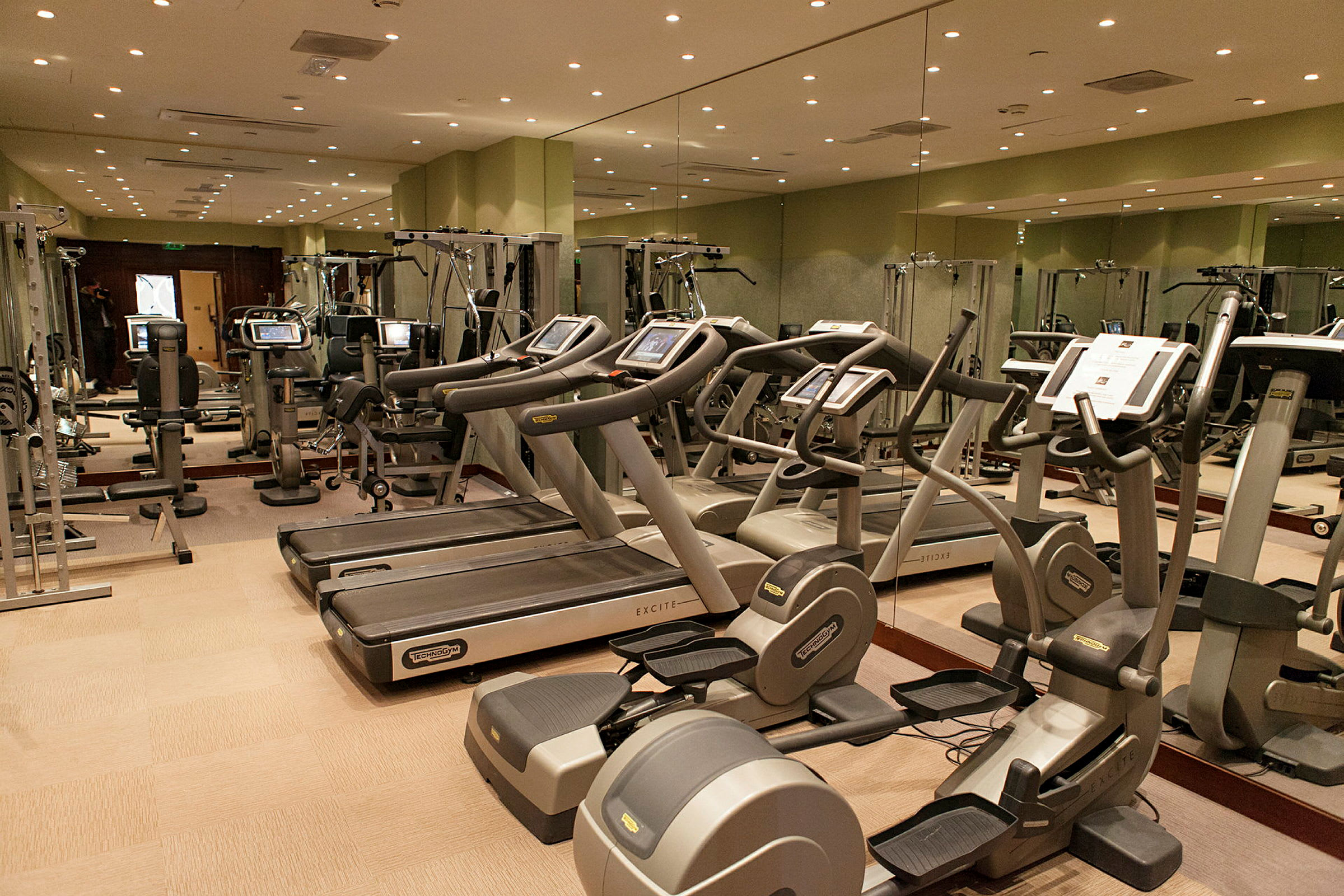 Billede af et fitnesscenter med træningsmaskiner såsom løbebånd og motionscykler. (AI-genereret tekst)