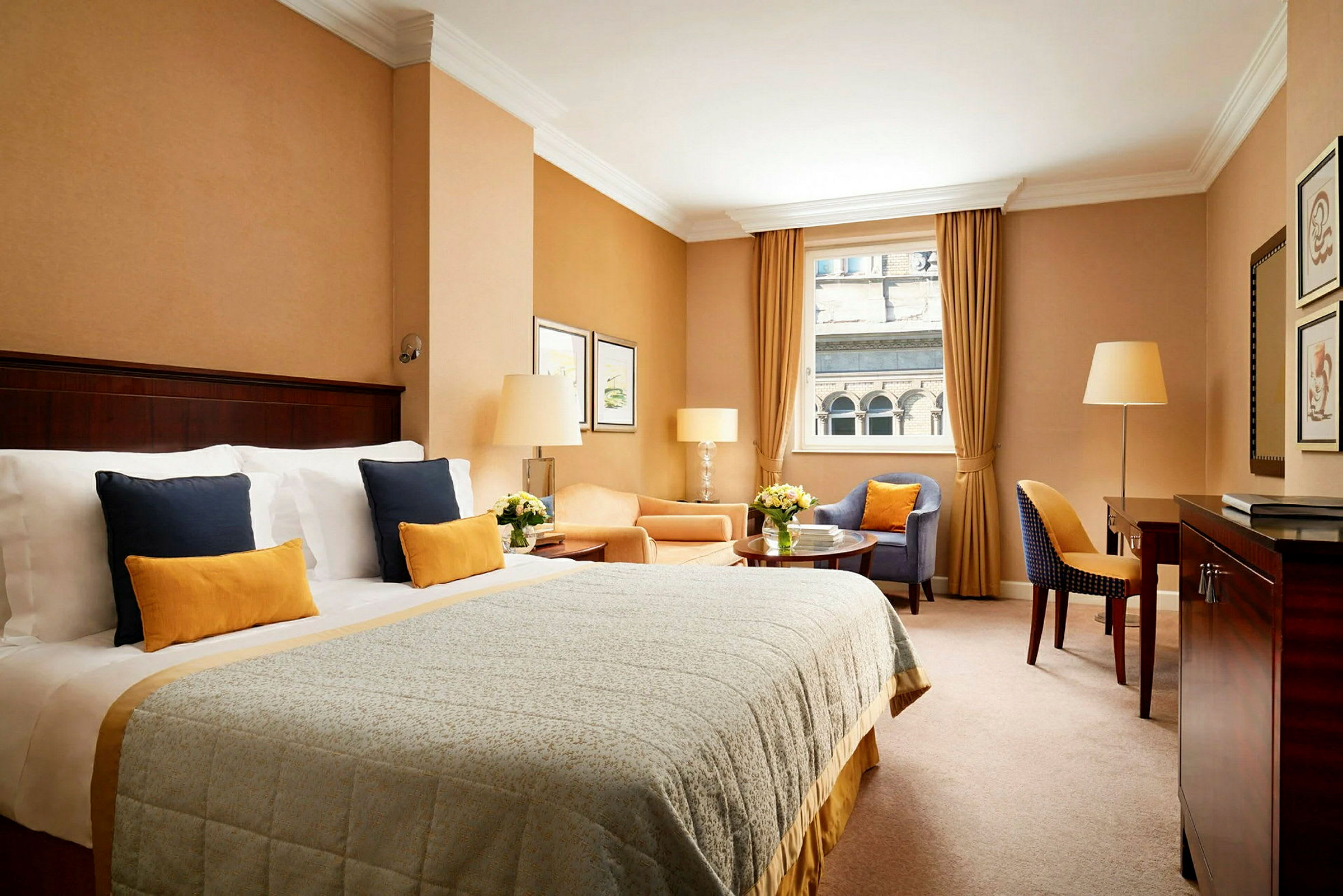 Et elegant hotelværelse med en bred seng, siddeområde og vindue med udsigt. (AI-genereret tekst)