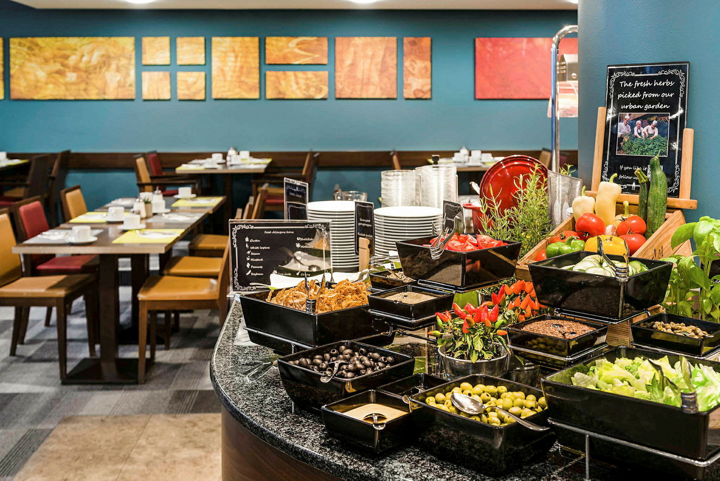 Billede af en buffet med friske grøntsager og tilbehør i et spiseområde. (AI-genereret tekst)