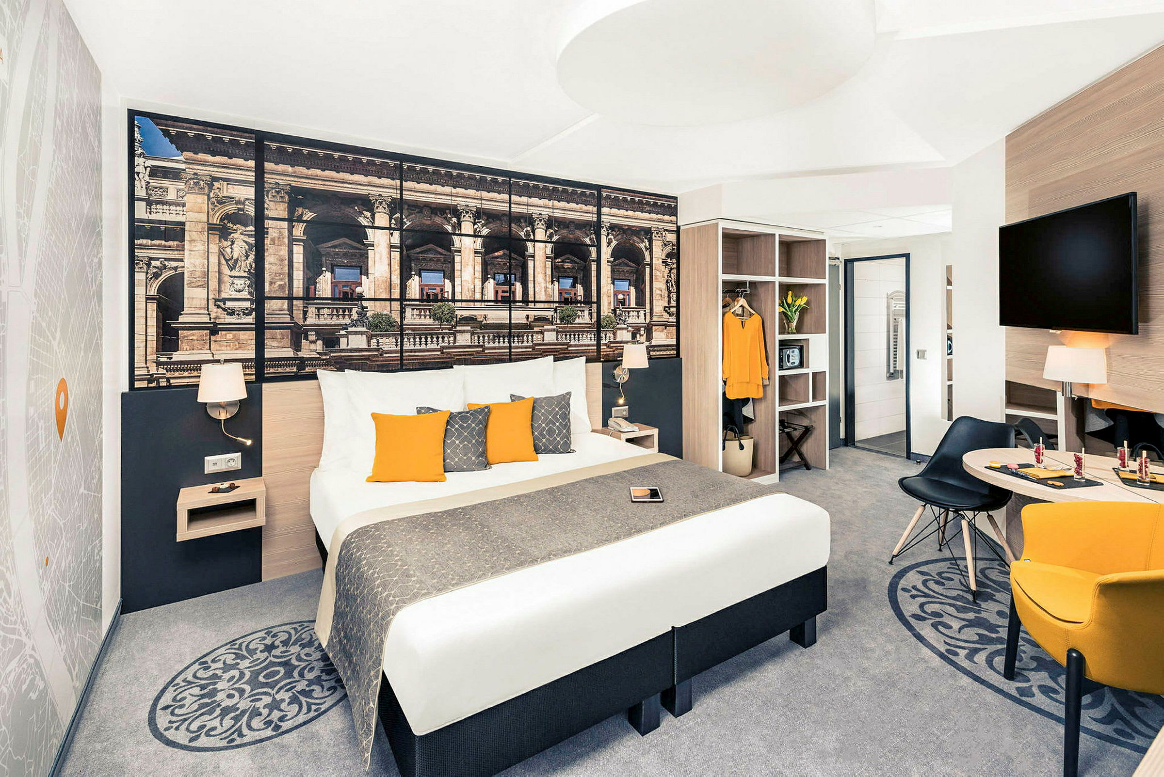 Hotelværelse med dobbeltseng, vægdekoration, siddeområde og garderobe. (AI-genereret tekst)