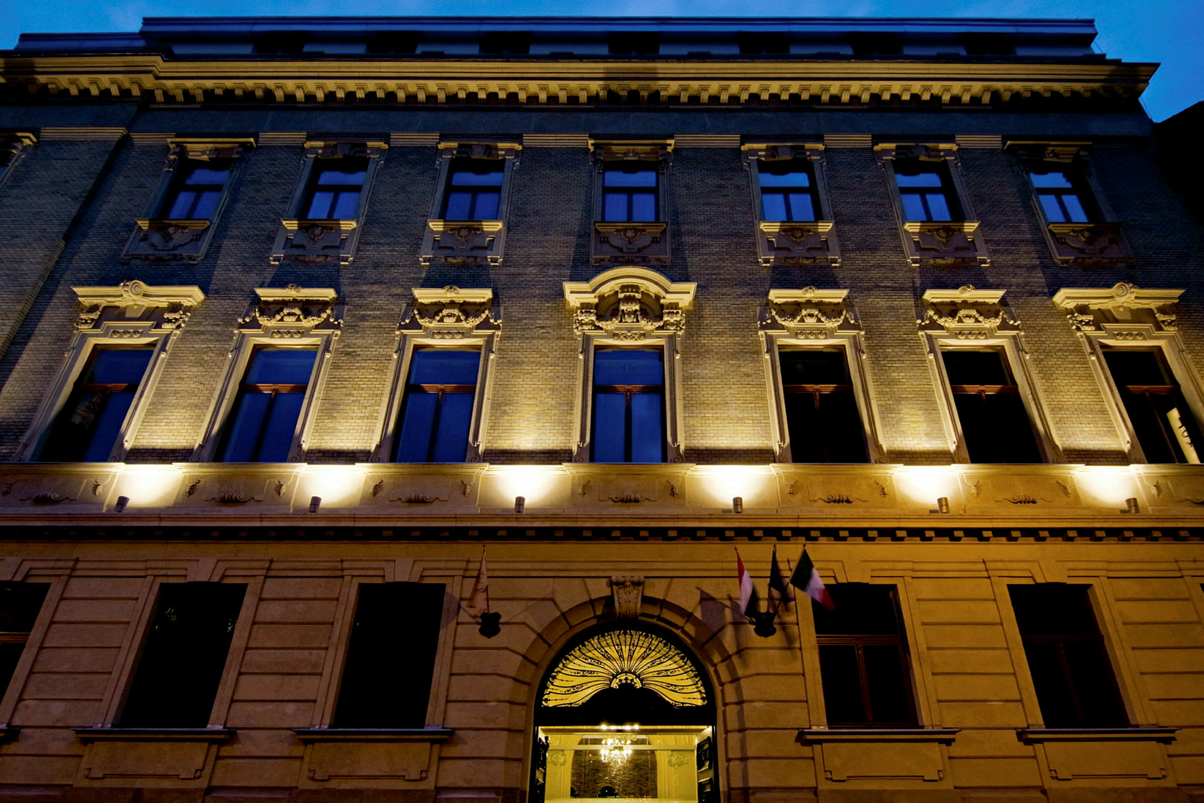 Bygningsfacade med oplyste vinduer og detaljeret arkitektur. (AI-genereret tekst)