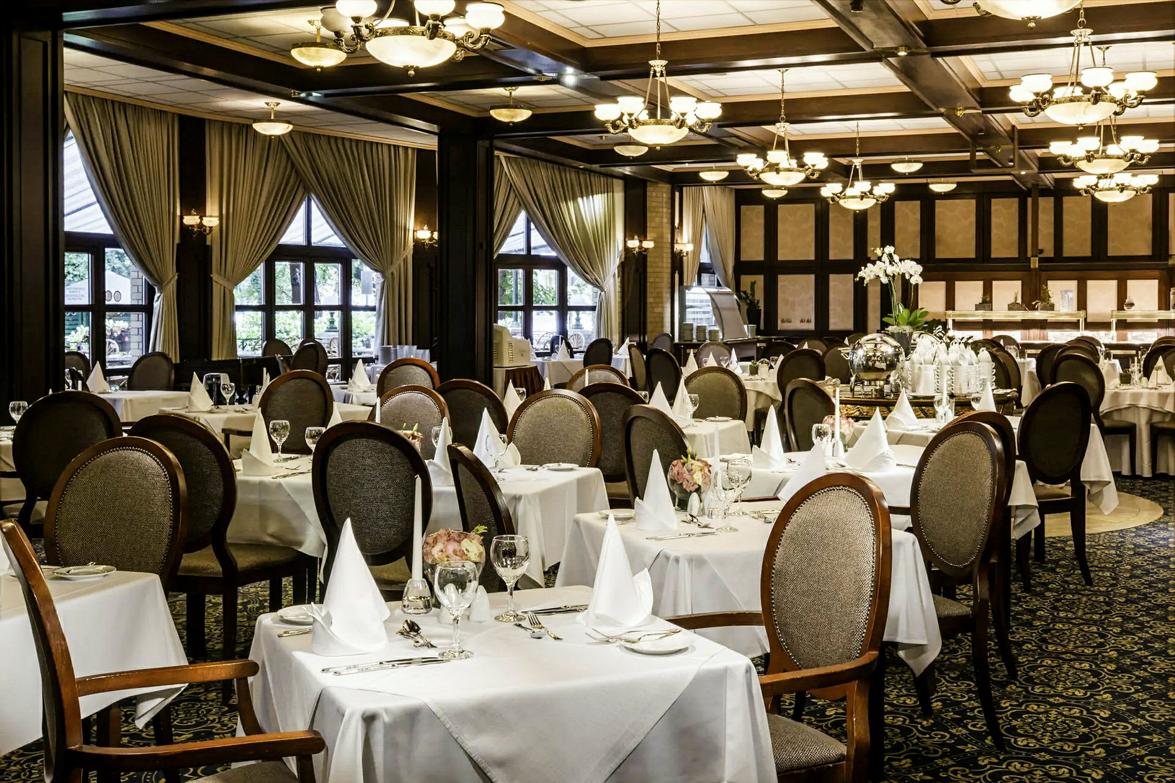 En elegant restaurant med dækkede borde og stole. (AI-genereret tekst)