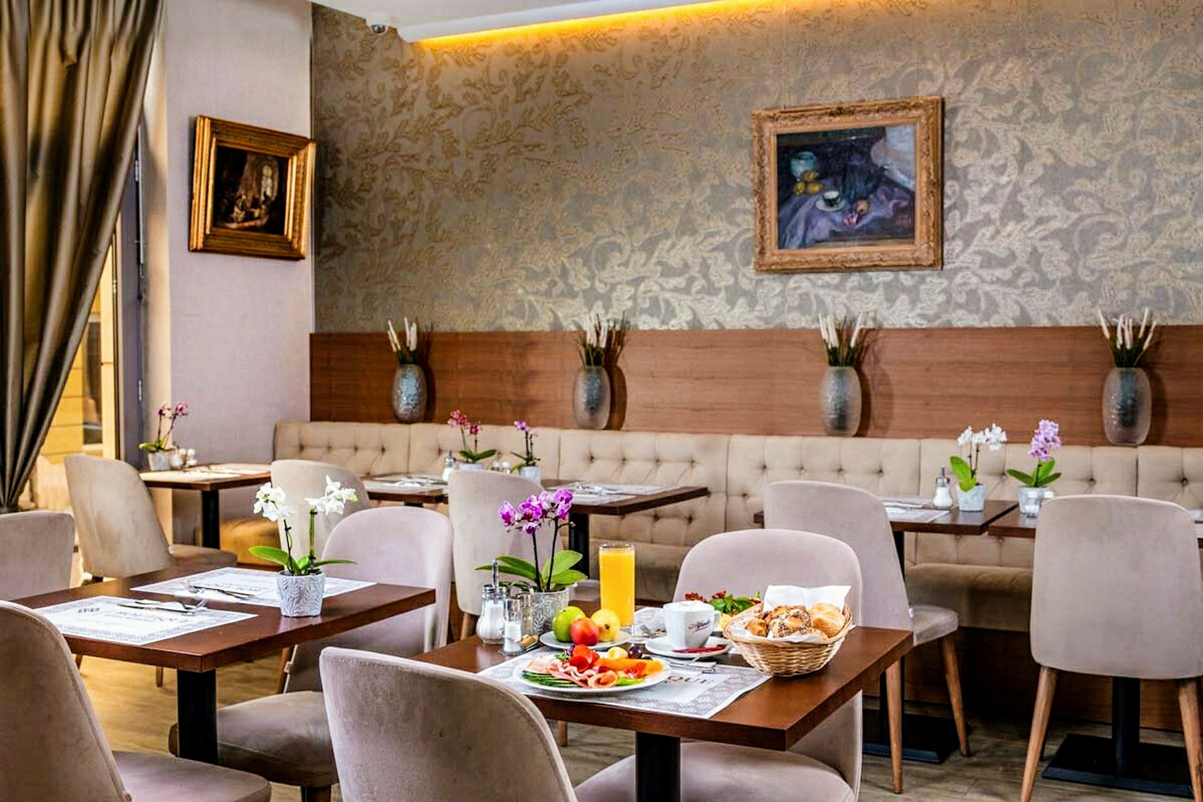 En stilfuldt møbleret café med små borde, stole og blomster samt morgenmad anrettet på et af bordene. (AI-genereret tekst)