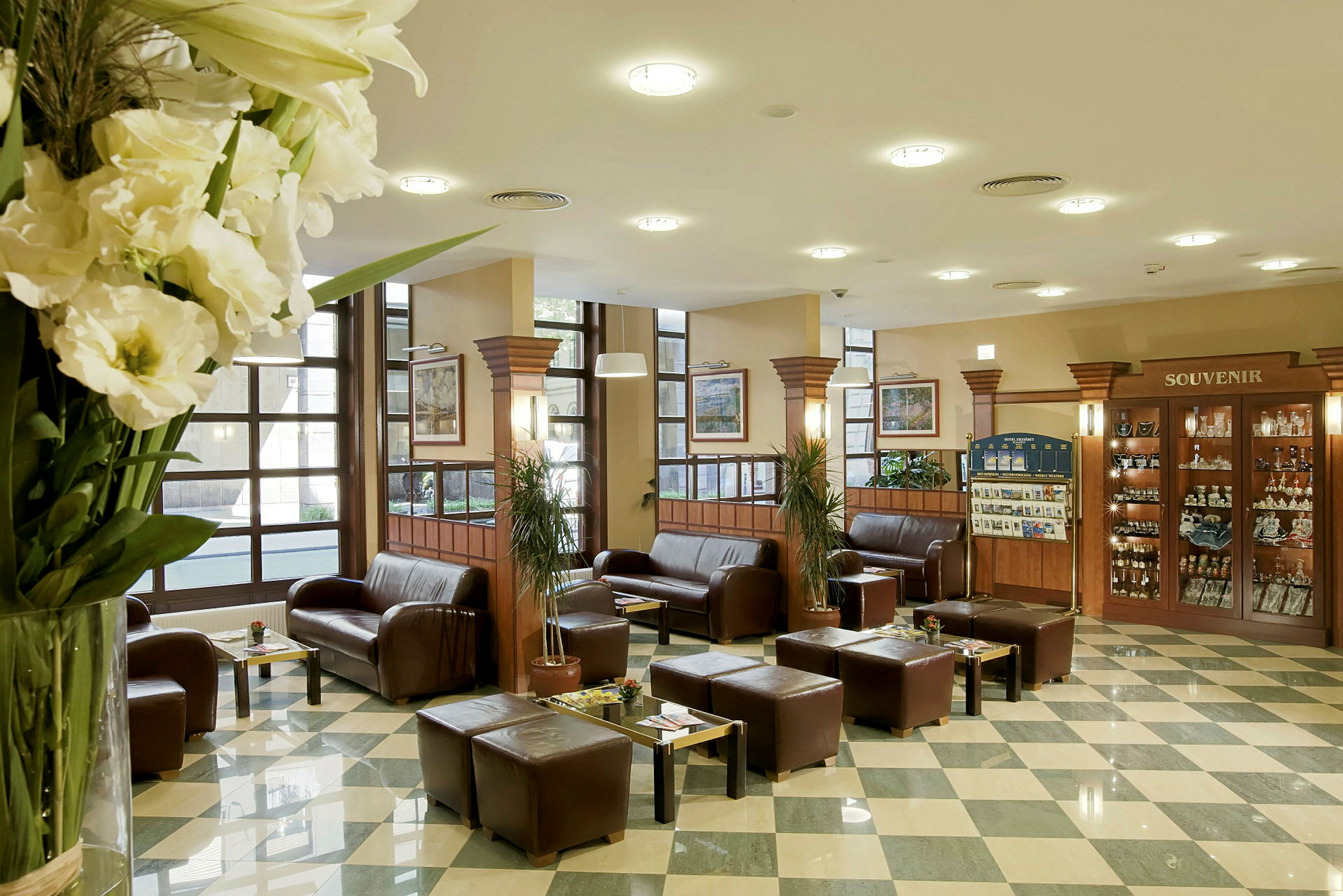 Hotellobby med sofaer, borde og souvenirer. (AI-genereret tekst)