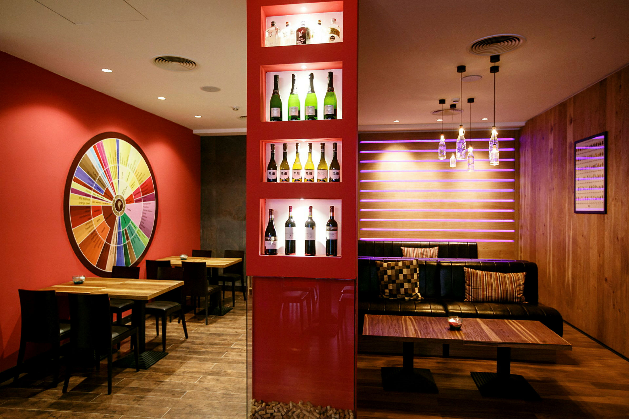 Restaurantinteriør med vinflasker på display og farverig dekoration. (AI-genereret tekst)