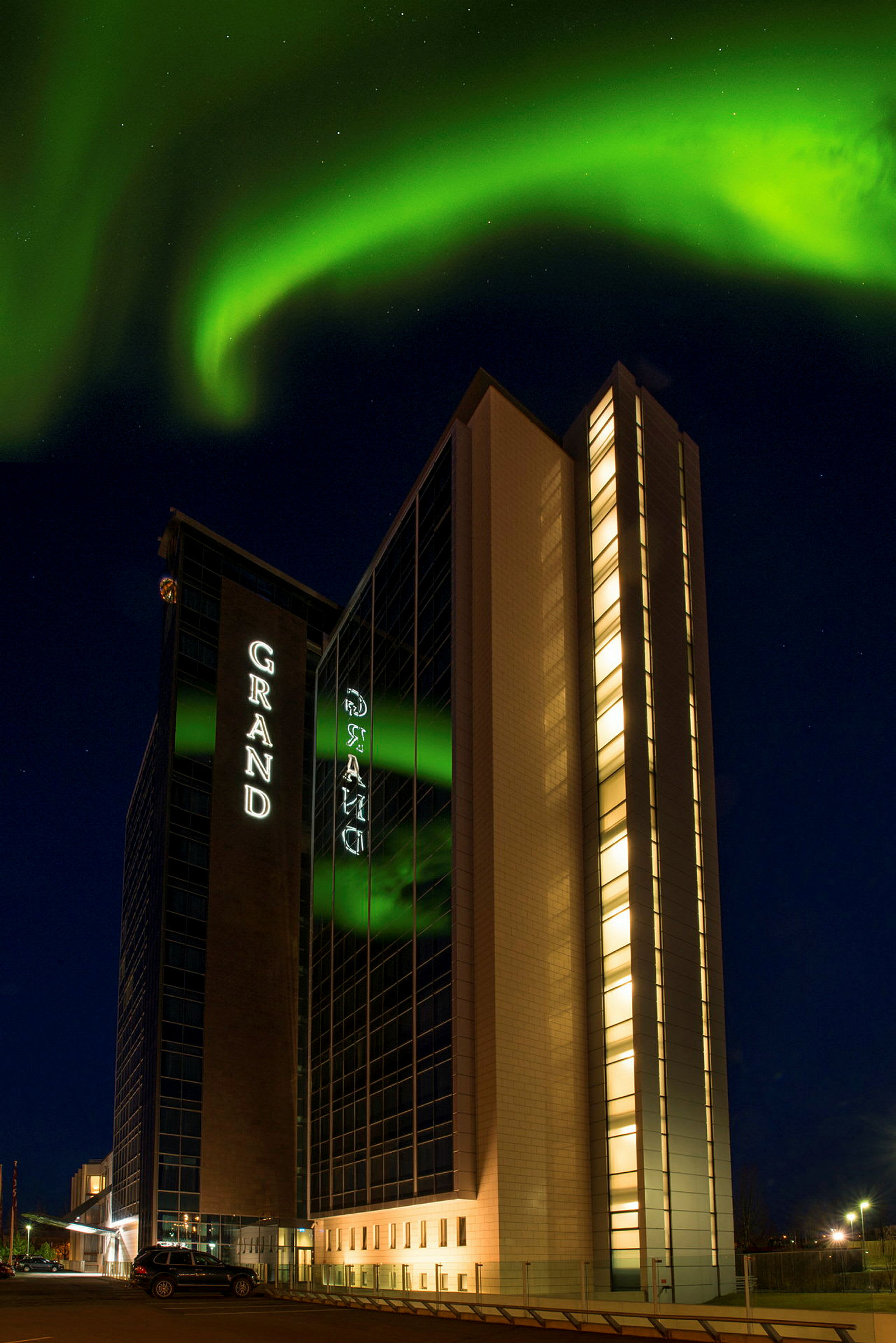 En bygning under nattehimlen med nordlys, der breder sig over himlen. (AI-genereret tekst)