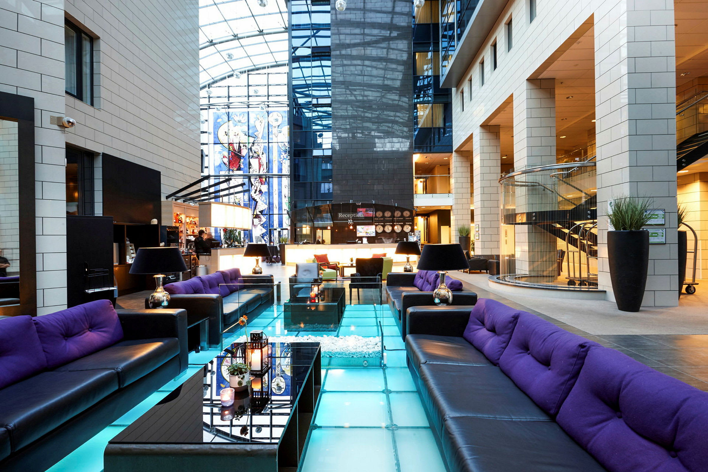 En moderne hotellobby med siddegrupper og glasgulv. (AI-genereret tekst)