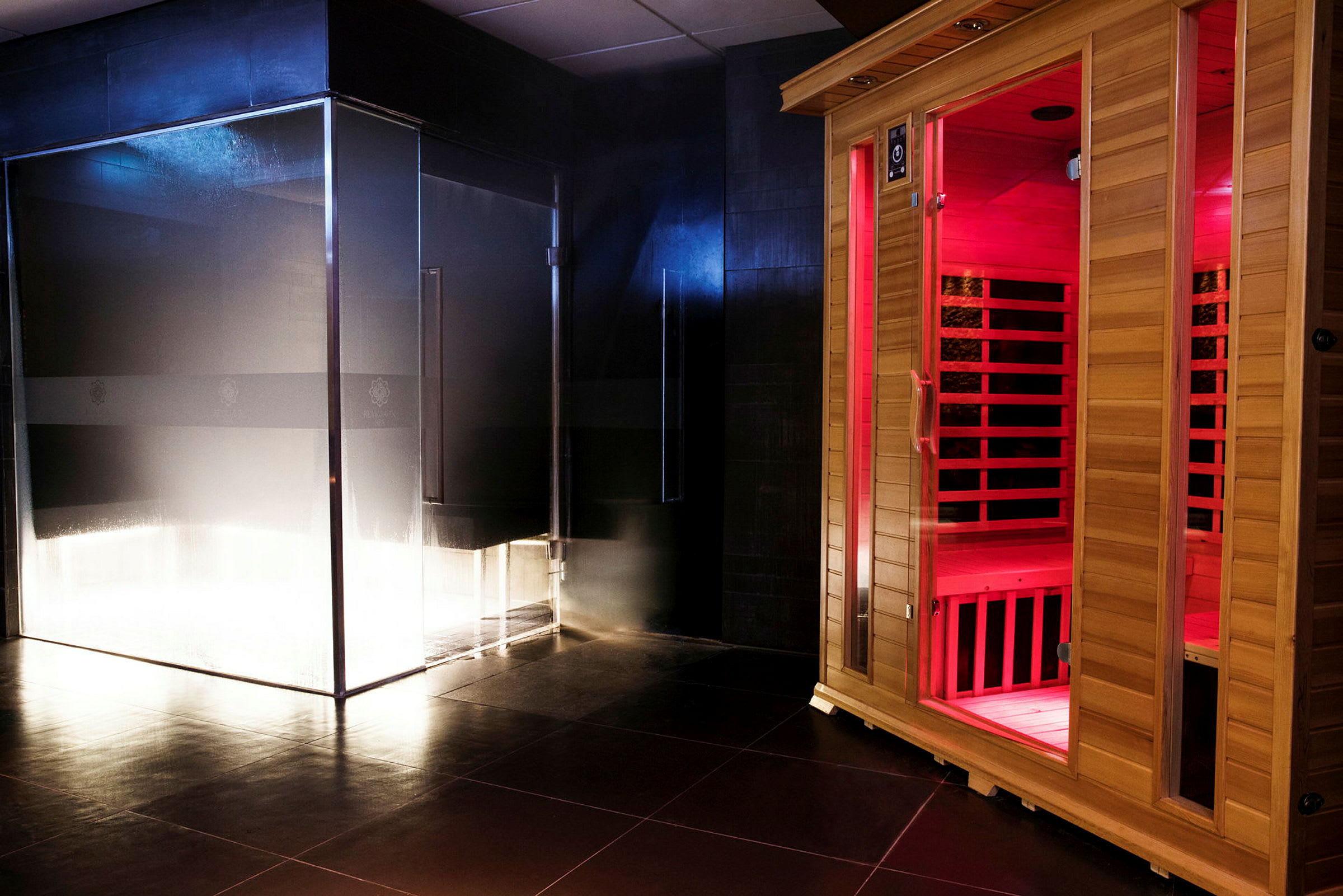 En sauna med glasvæg og en saunakabine i træ med rød belysning. (AI-genereret tekst)
