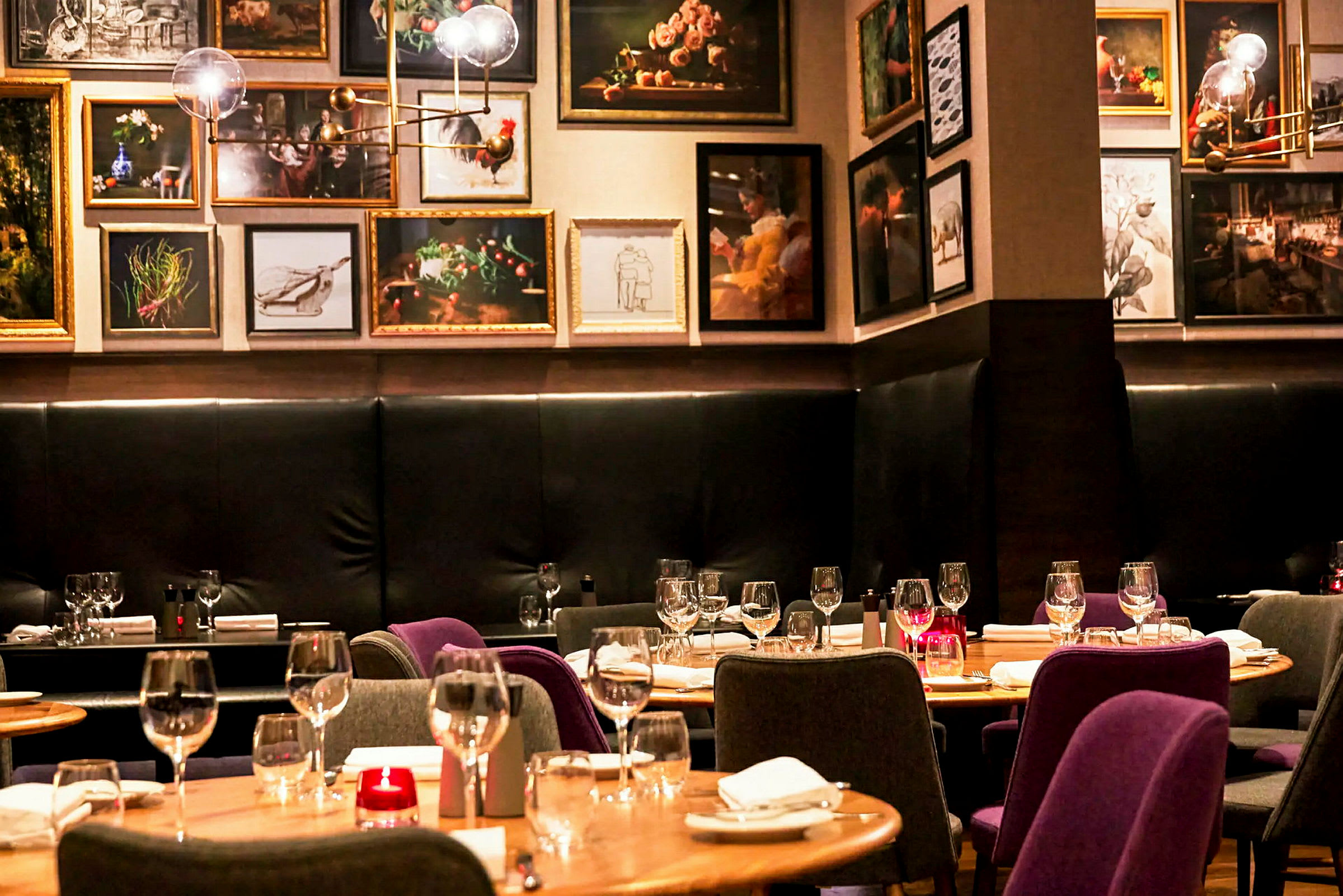 Interiør af en restaurant med dækkede borde og kunstværker på væggene. (AI-genereret tekst)