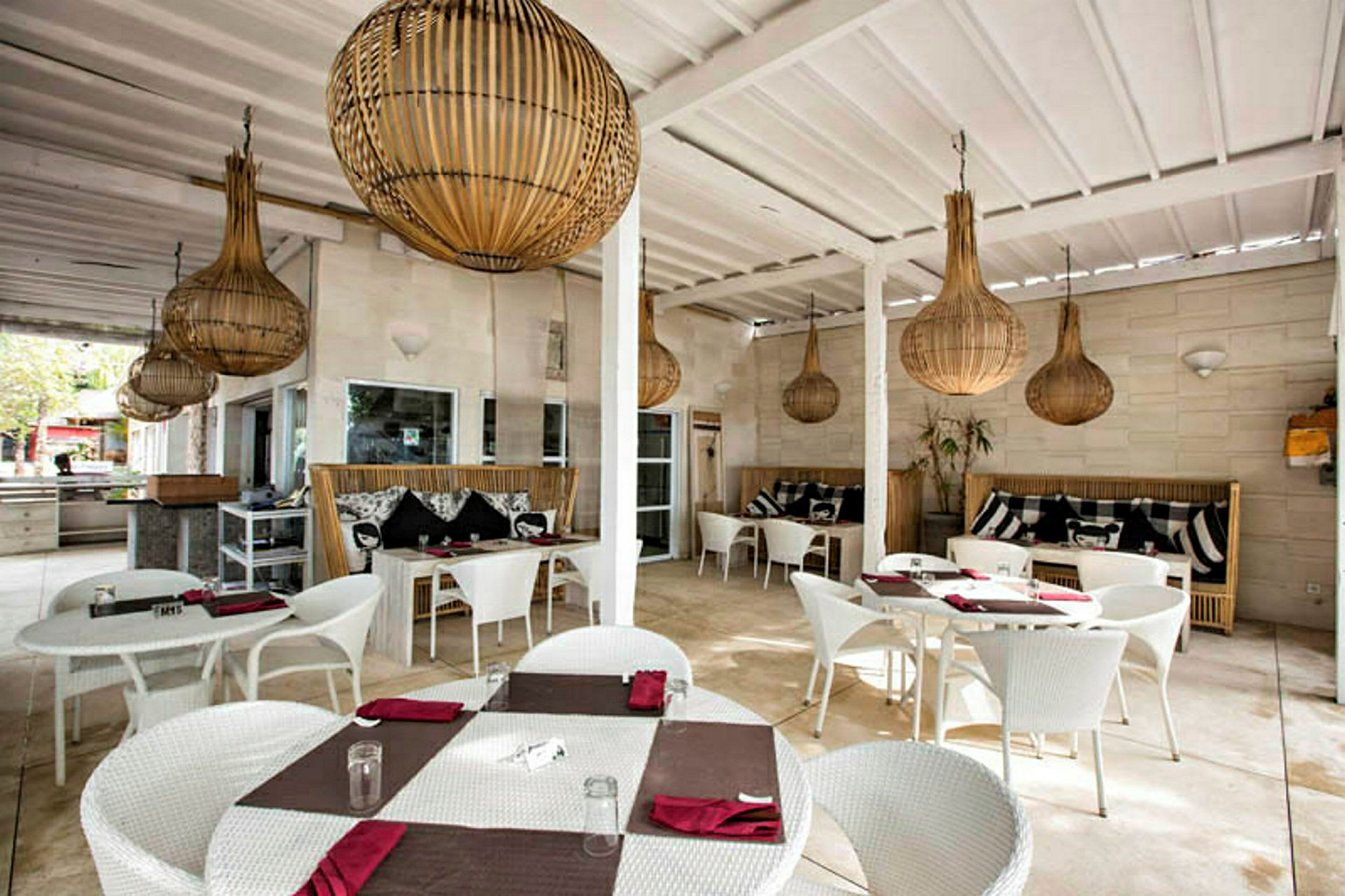 Restaurantområde med hvide borde og stole samt dekorative lamper i loftet. (AI-genereret tekst)