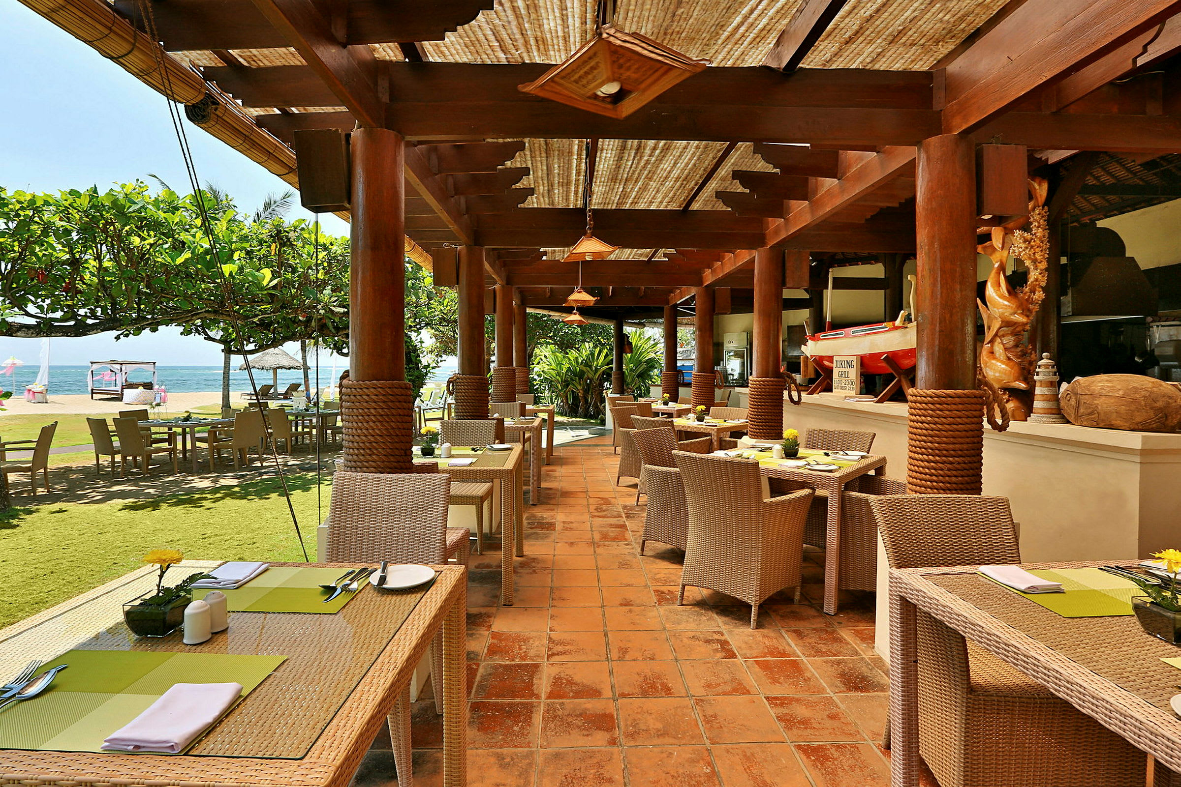 Restaurant med udendørs siddepladser og udsigt over havet. (AI-genereret tekst)