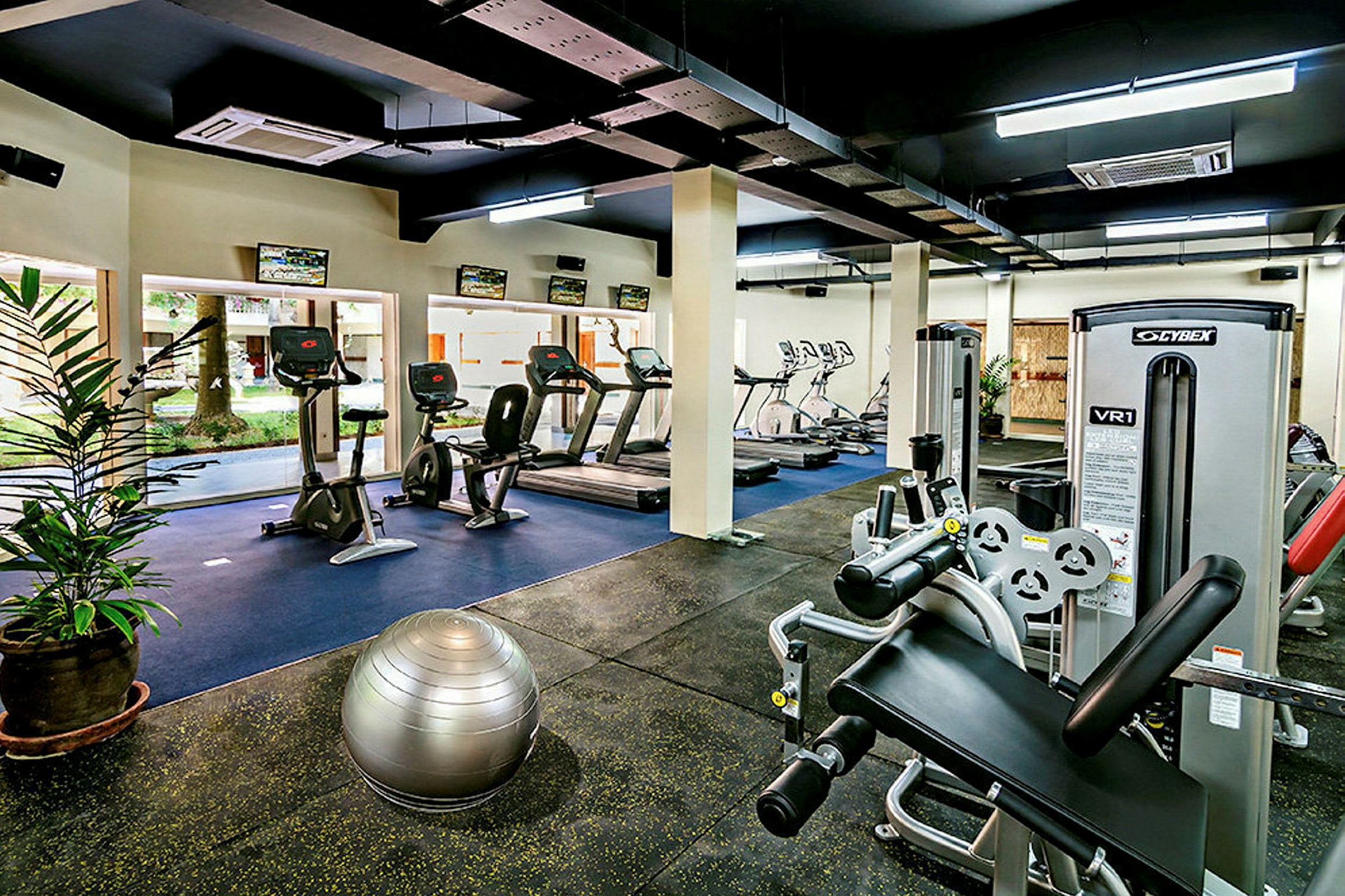 Et fitnesscenter fyldt med forskellige træningsmaskiner og udstyr. (AI-genereret tekst)