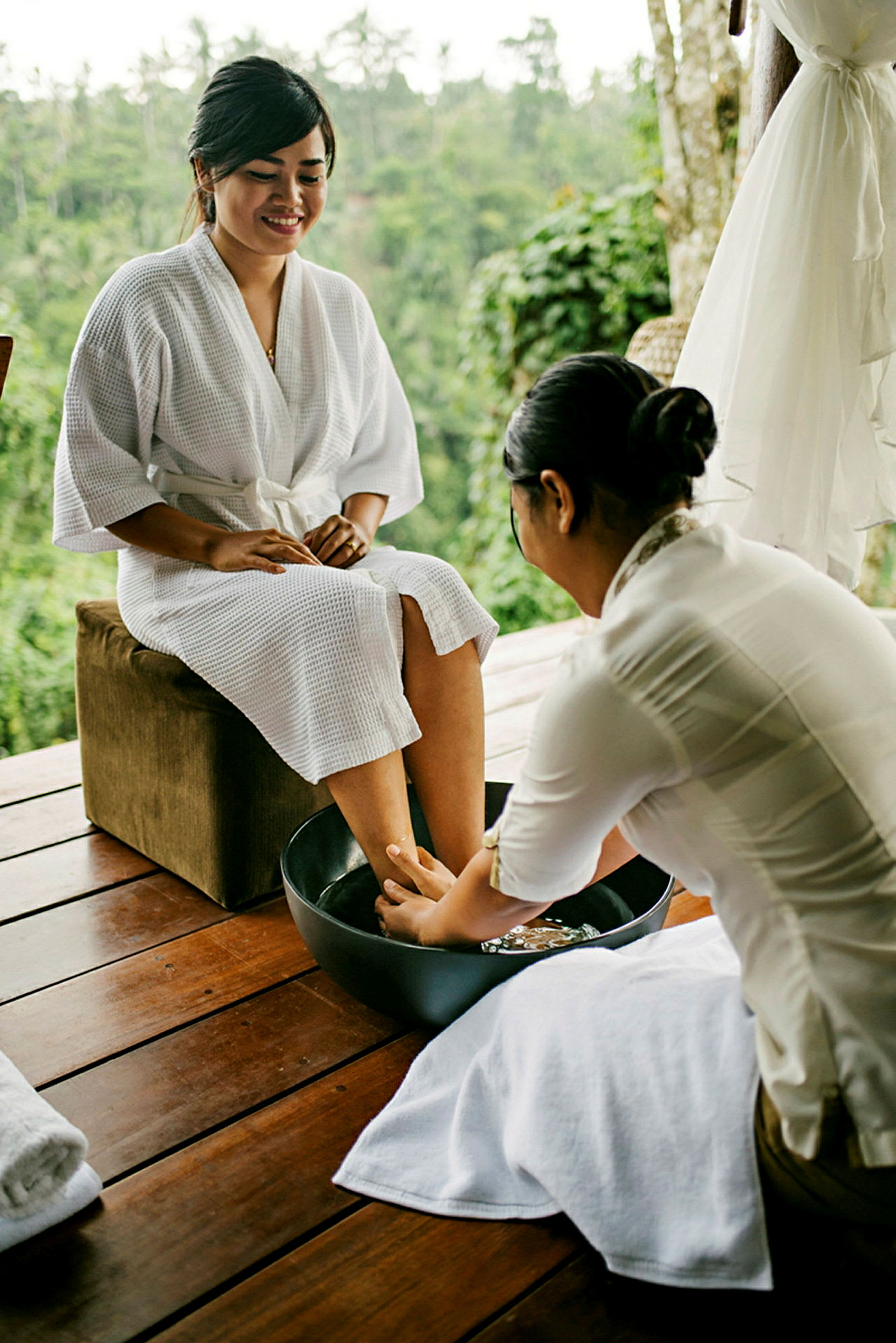 En person, der modtager fodmassage på en spa-facilitet med naturen i baggrunden. (AI-genereret tekst)