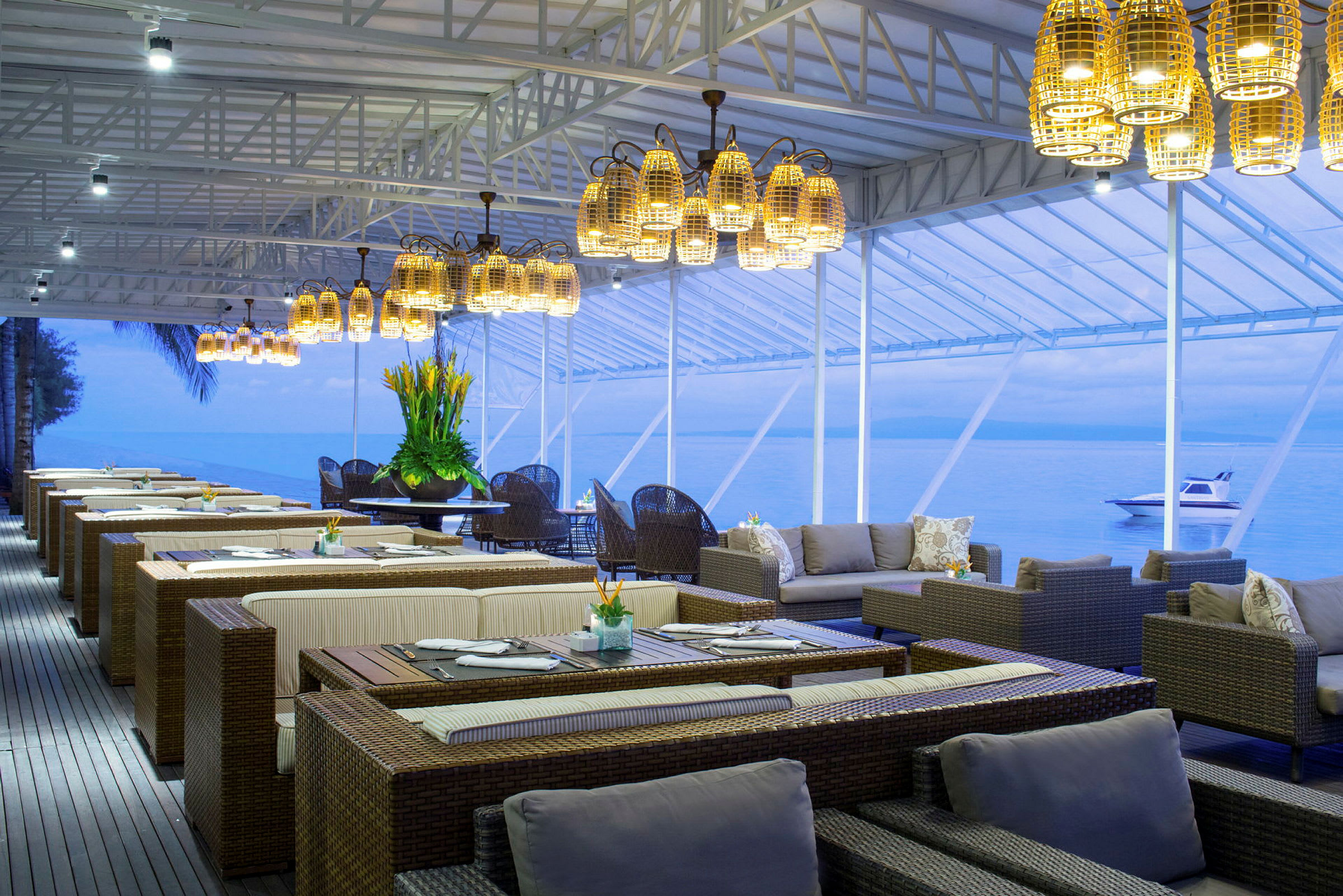 Restaurant område med udsigt over havet ved solnedgang. (AI-genereret tekst)