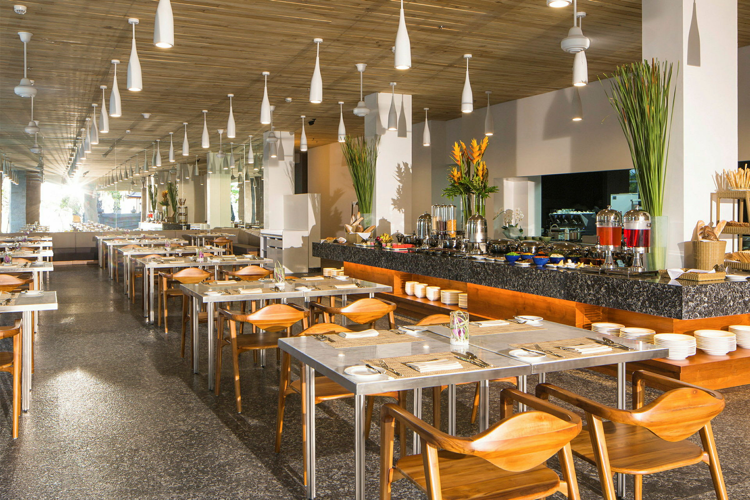 Interiøret i en restaurant med dækkede borde og en buffet med forskellige drikkevarer og tilbehør. (AI-genereret tekst)
