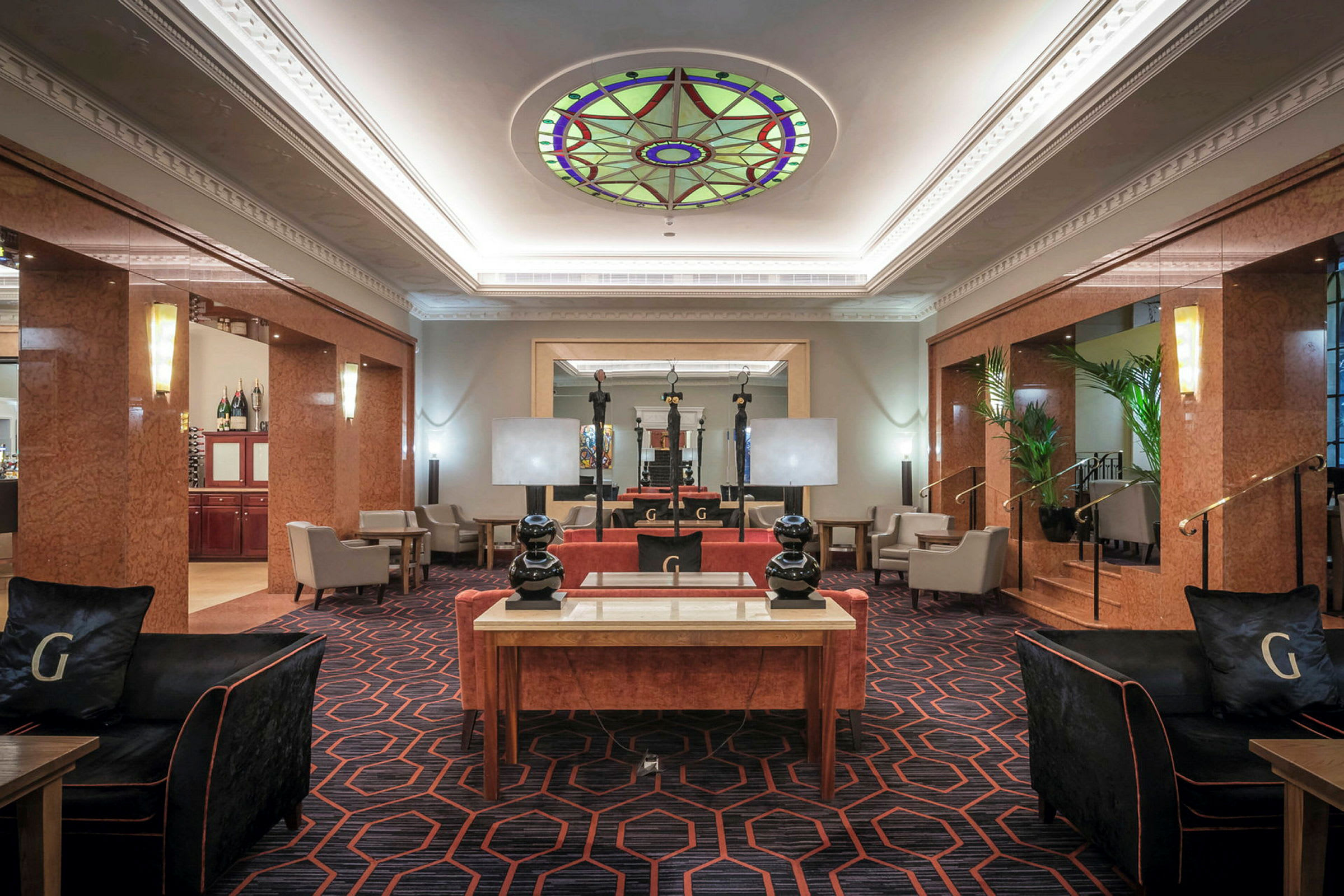 En hotellobby med komfortable møbler og dekorativt glasloft. (AI-genereret tekst)