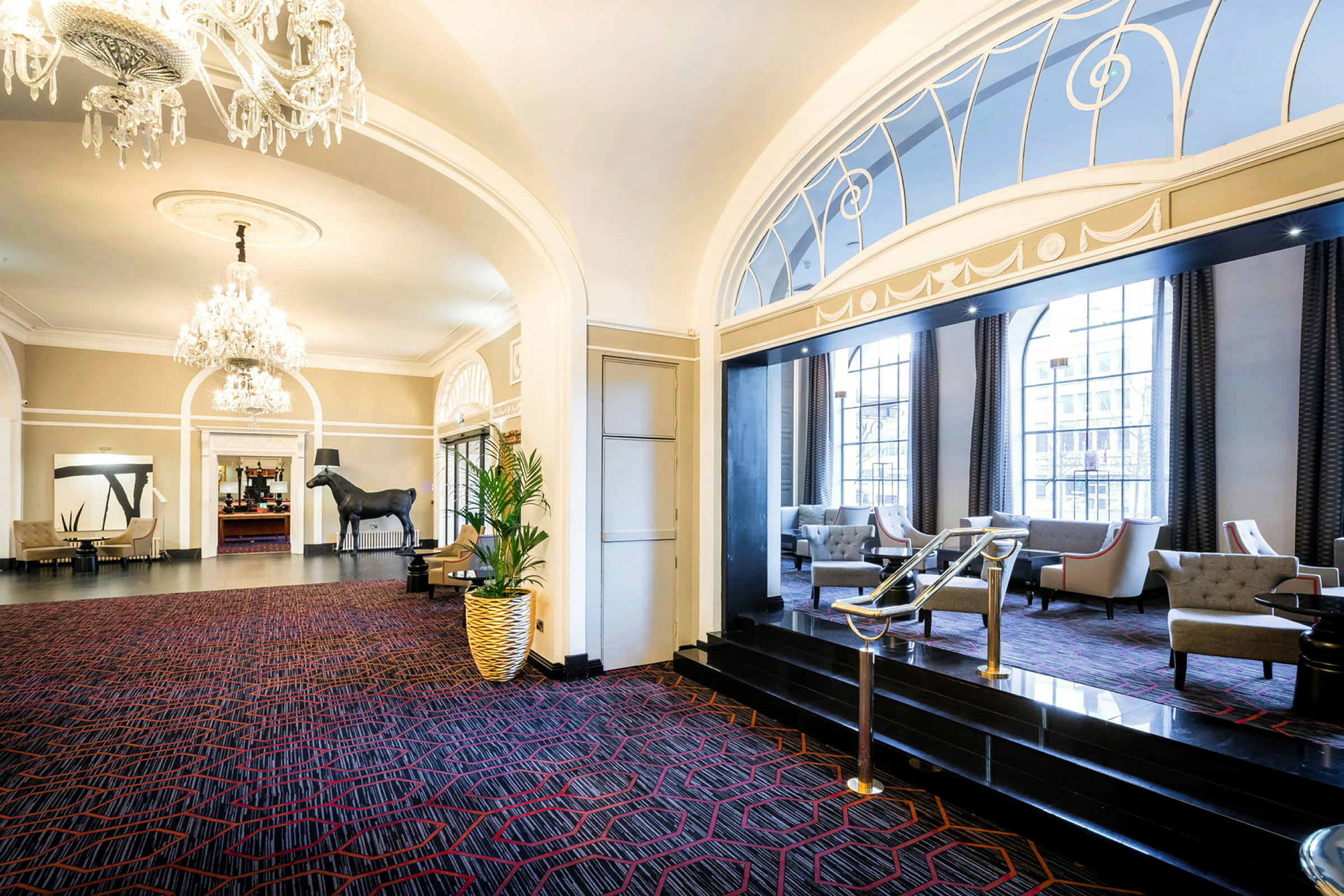 Hotellets lobby med luksuriøse møbler, lysekrone og dekorativ indretning. (AI-genereret tekst)