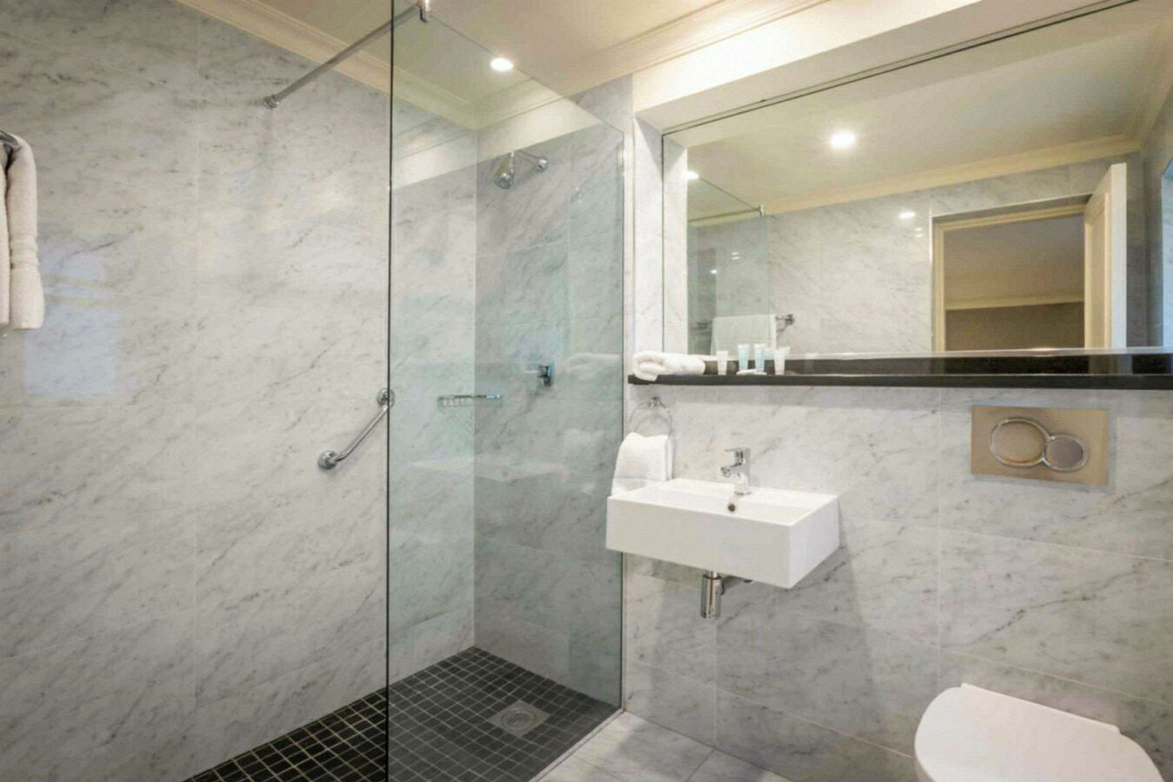 Moderne badeværelse med bruser, håndvask og toilet. (AI-genereret tekst)