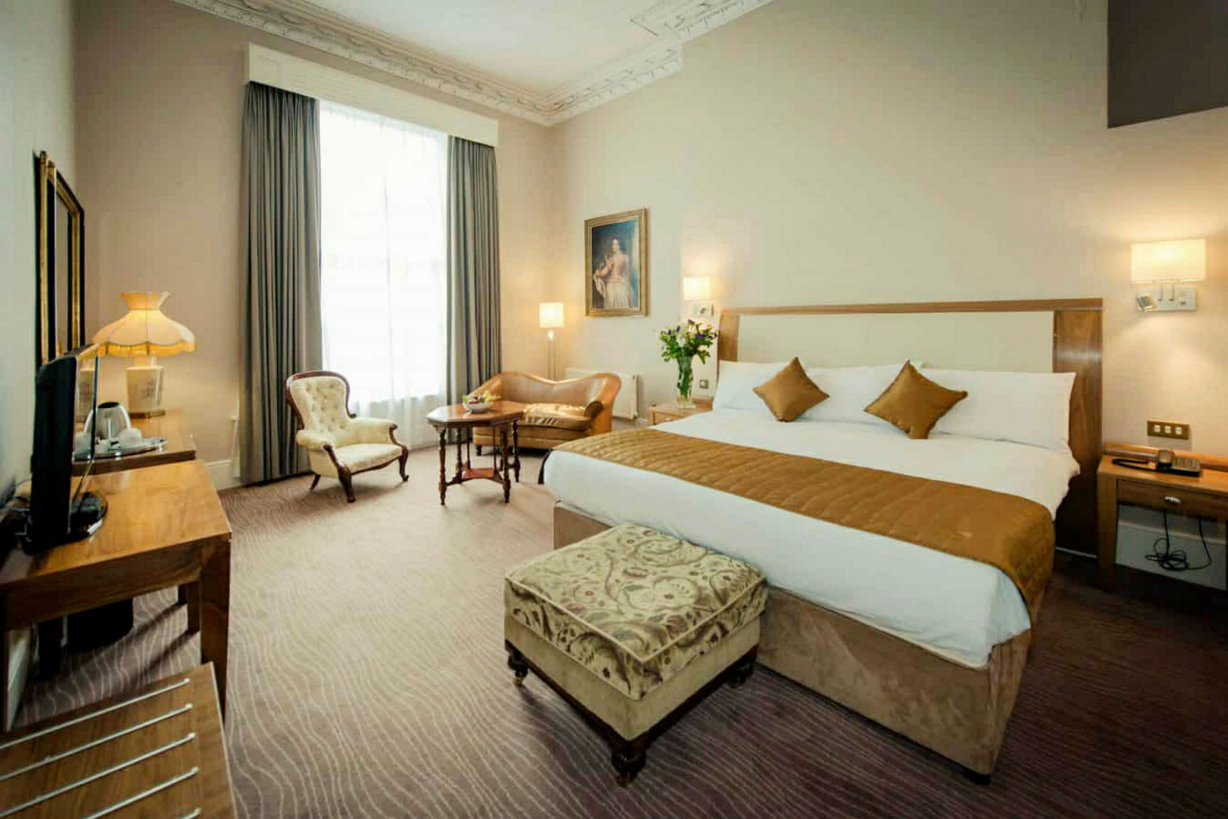 Hotelværelse med stor seng og siddepladser. (AI-genereret tekst)