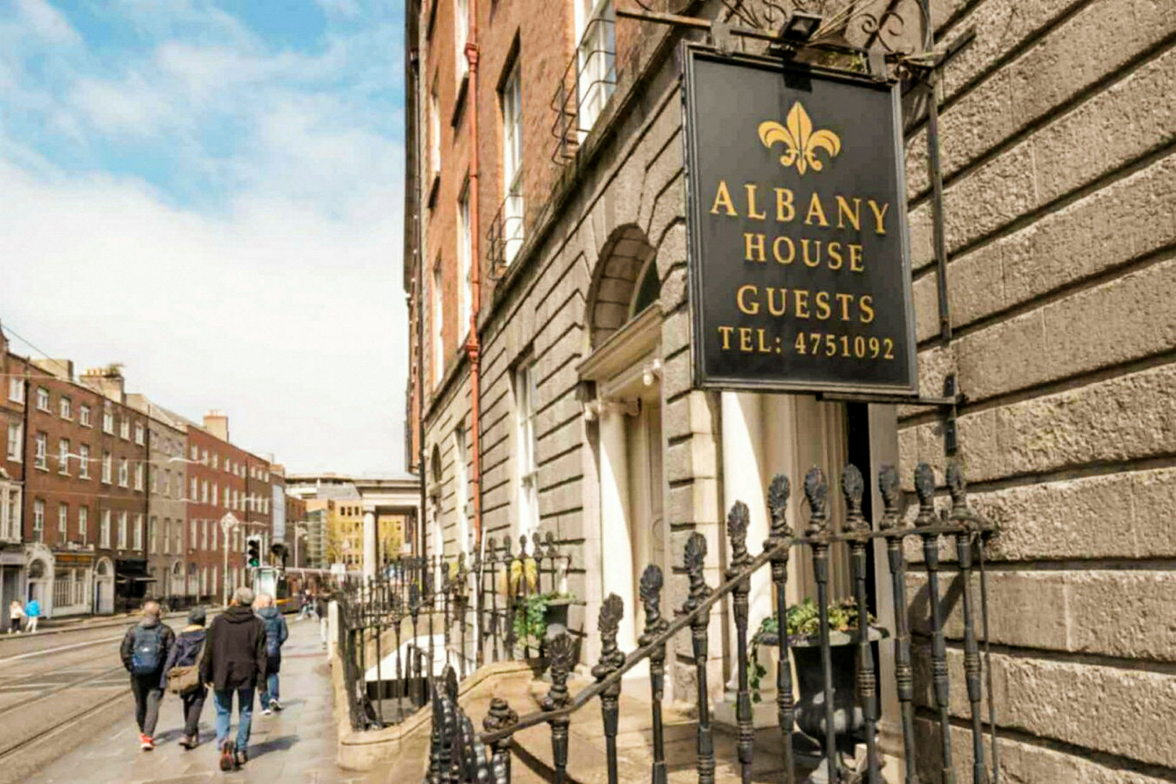 Skilt med teksten Albany House Guests ved en husfacade. (AI-genereret tekst)