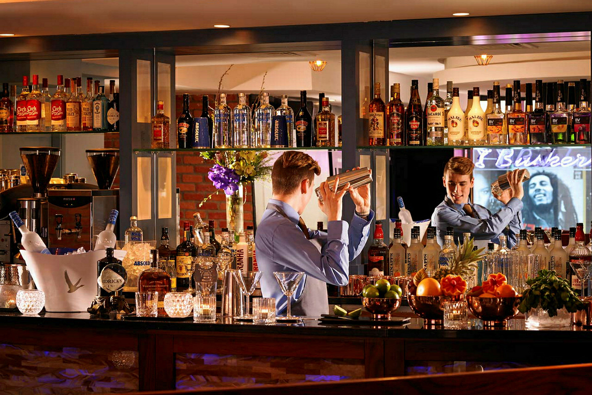 En bartender blander en cocktail bag en velassorteret bar. (AI-genereret tekst)