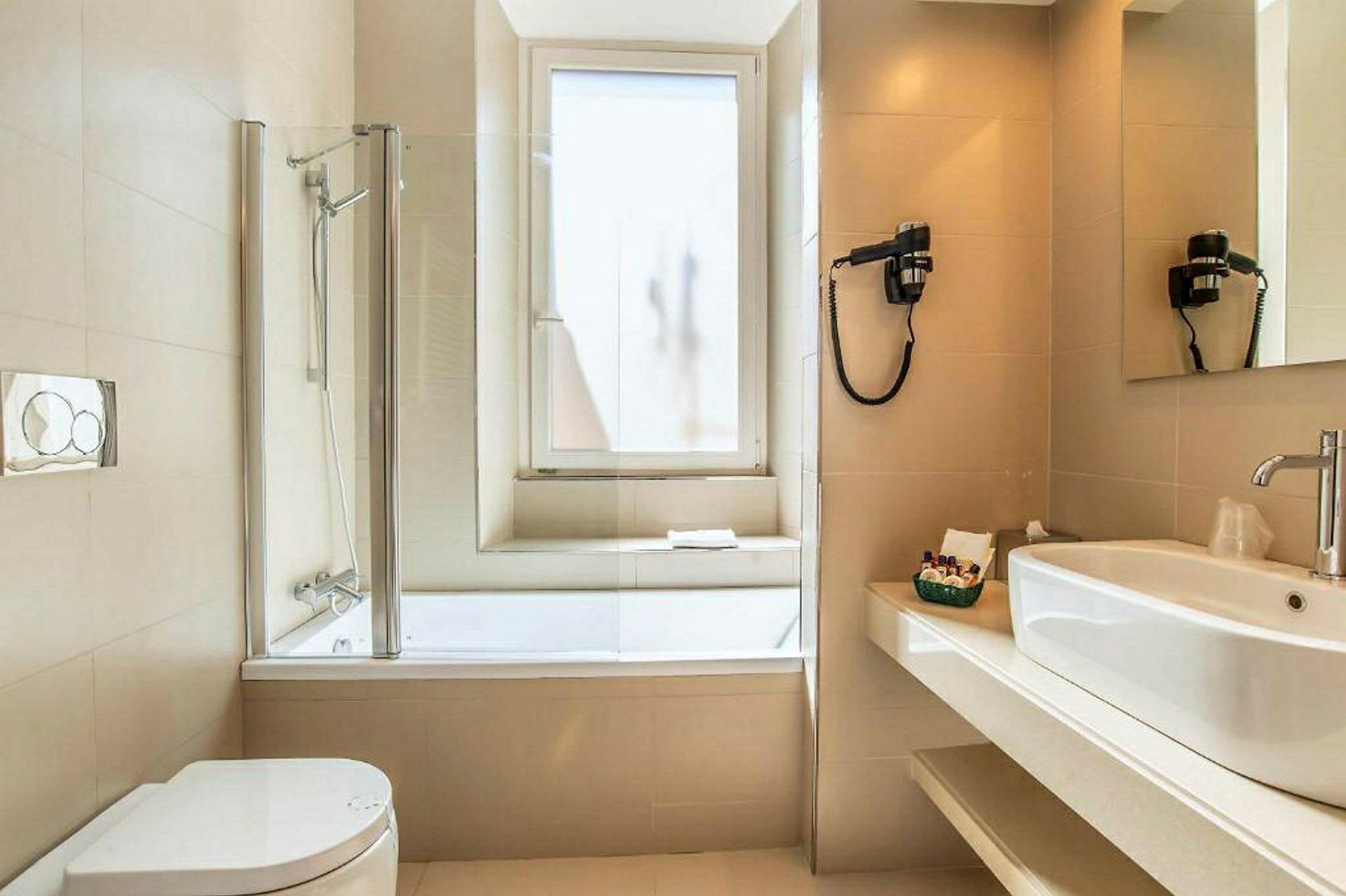 Et badeværelse med badekar, toilet, håndvask og spejl. (AI-genereret tekst)