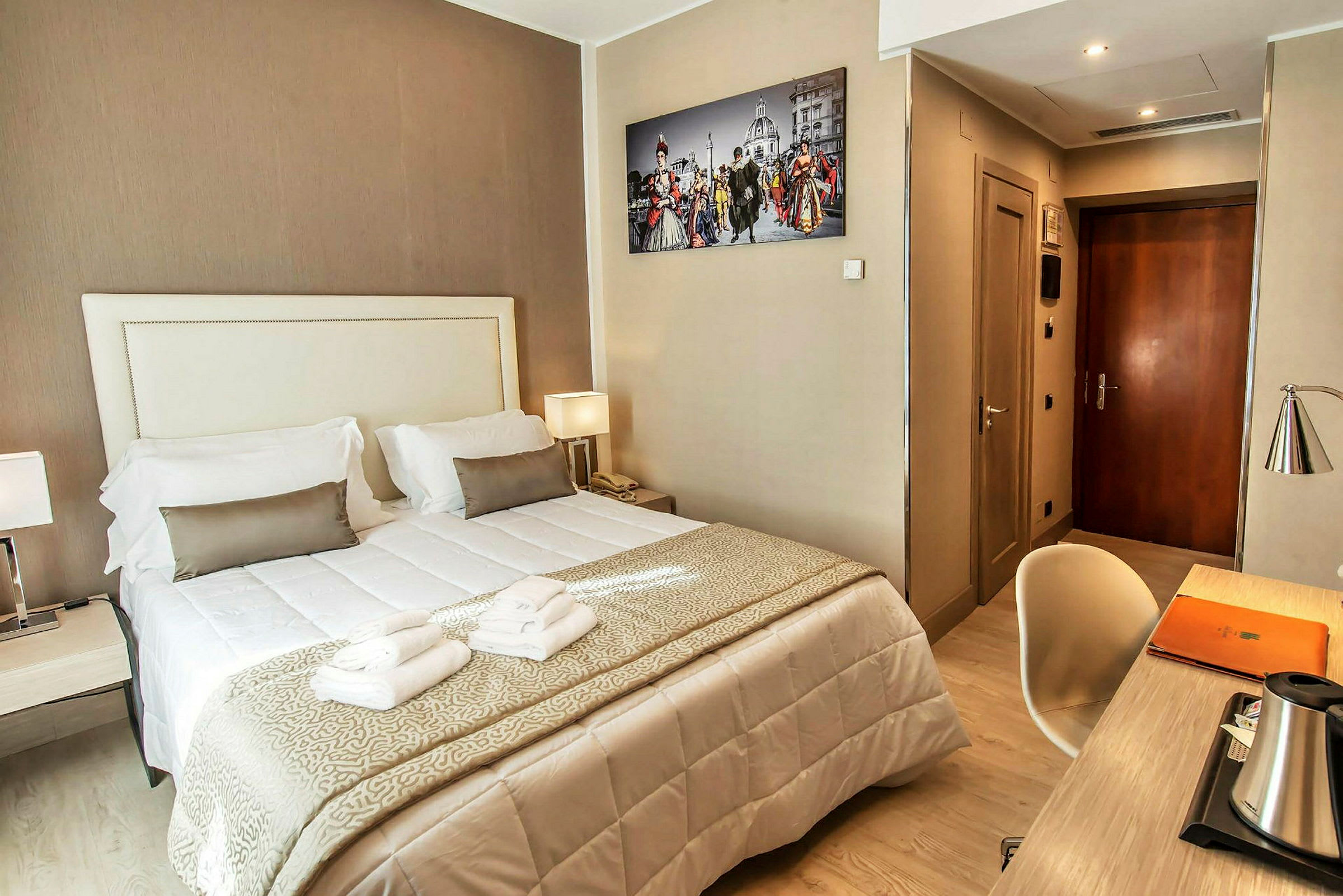 Hotelværelse med dobbeltseng, skrivebord og vægfotografi. (AI-genereret tekst)