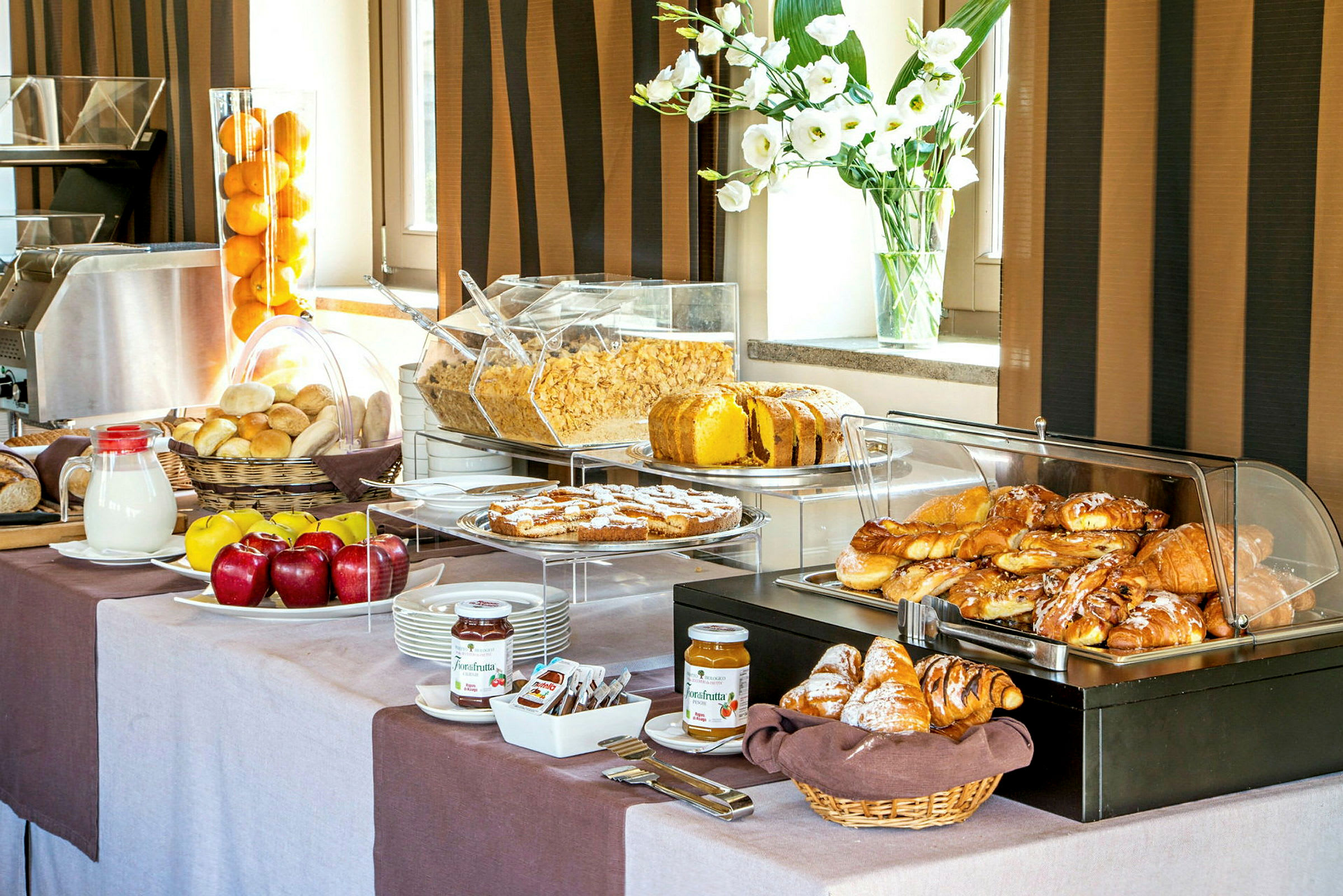 En buffet med morgenmadsmad som frisk brød, croissanter, frugt, morgenmadsprodukter og forskellige toppings. (AI-genereret tekst)