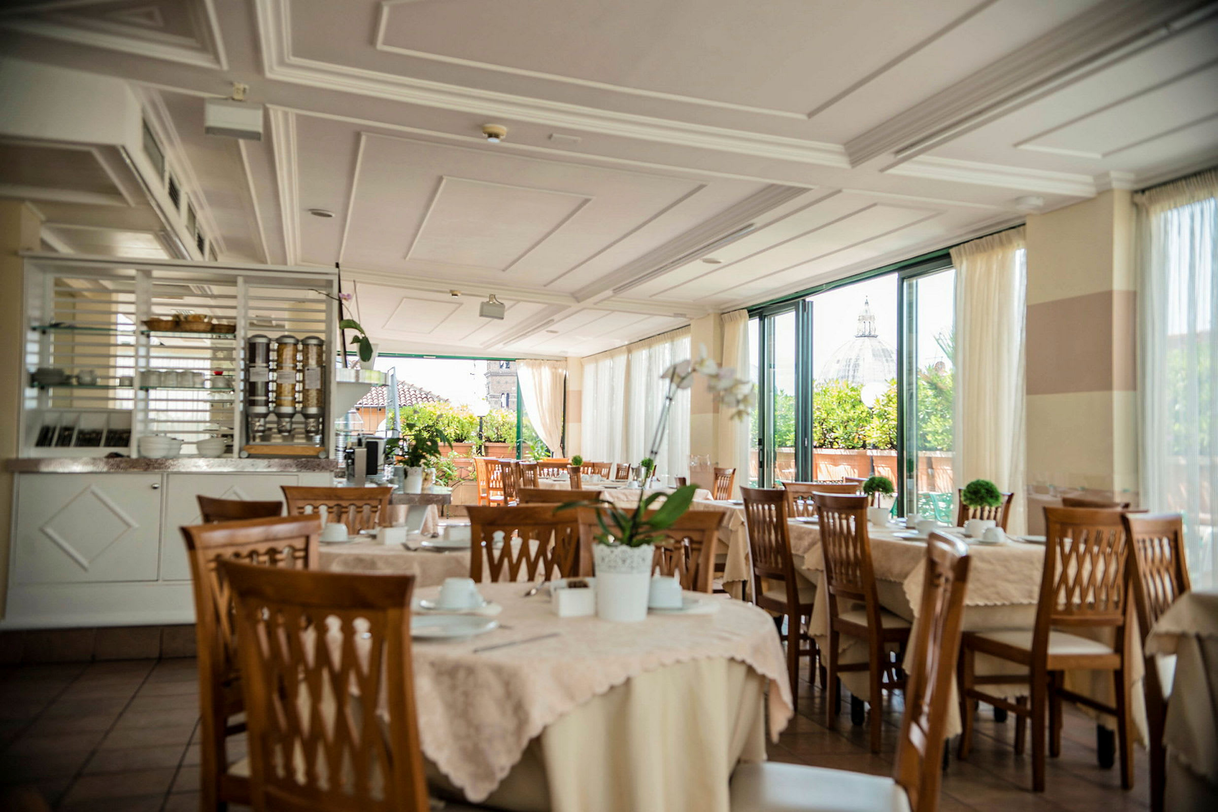 En restaurant med dækkede borde og udsigt til en bygning med kuppel. (AI-genereret tekst)