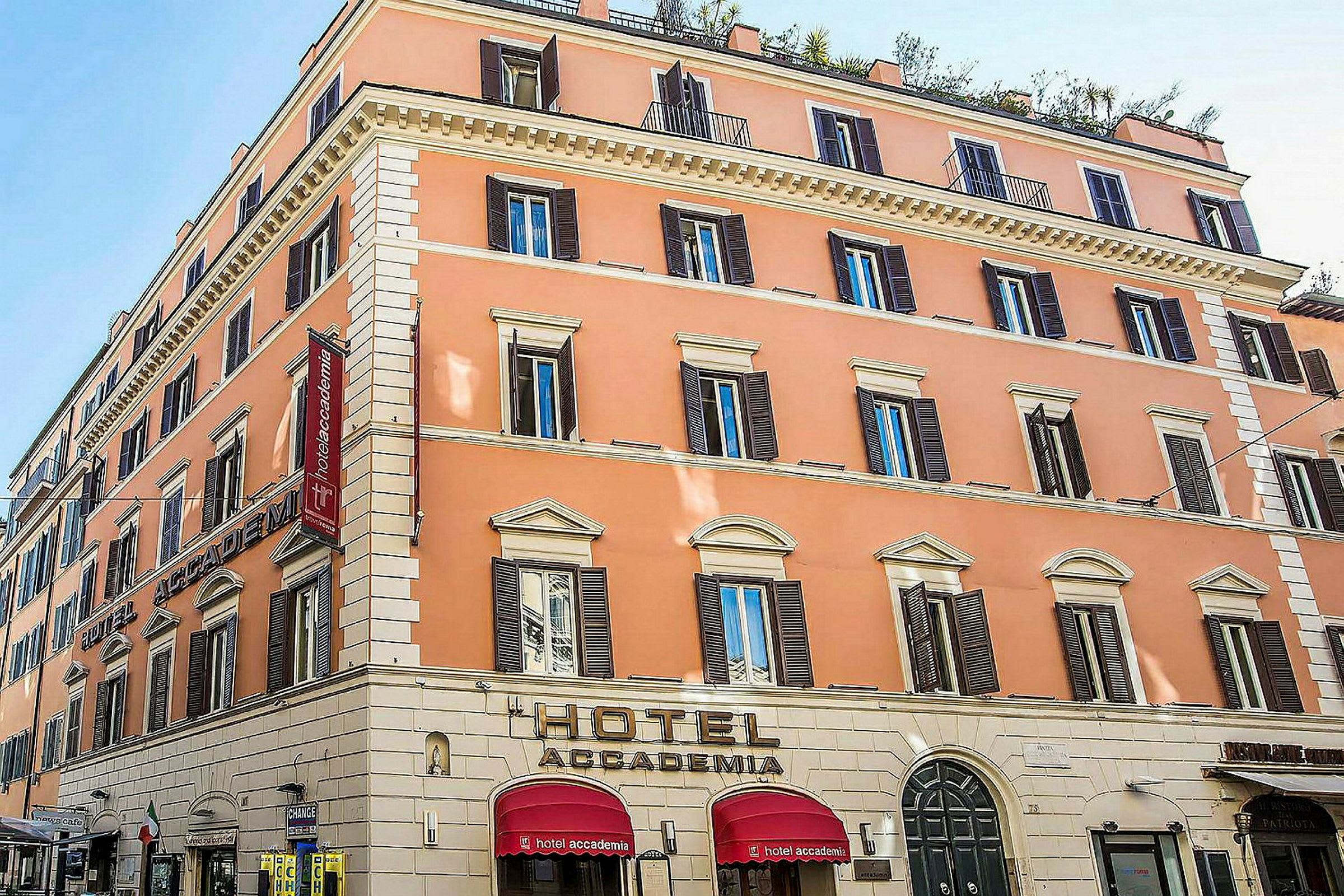 Et hotel i en pastelfarvet bygning med flere etager og mange vinduer. (AI-genereret tekst)