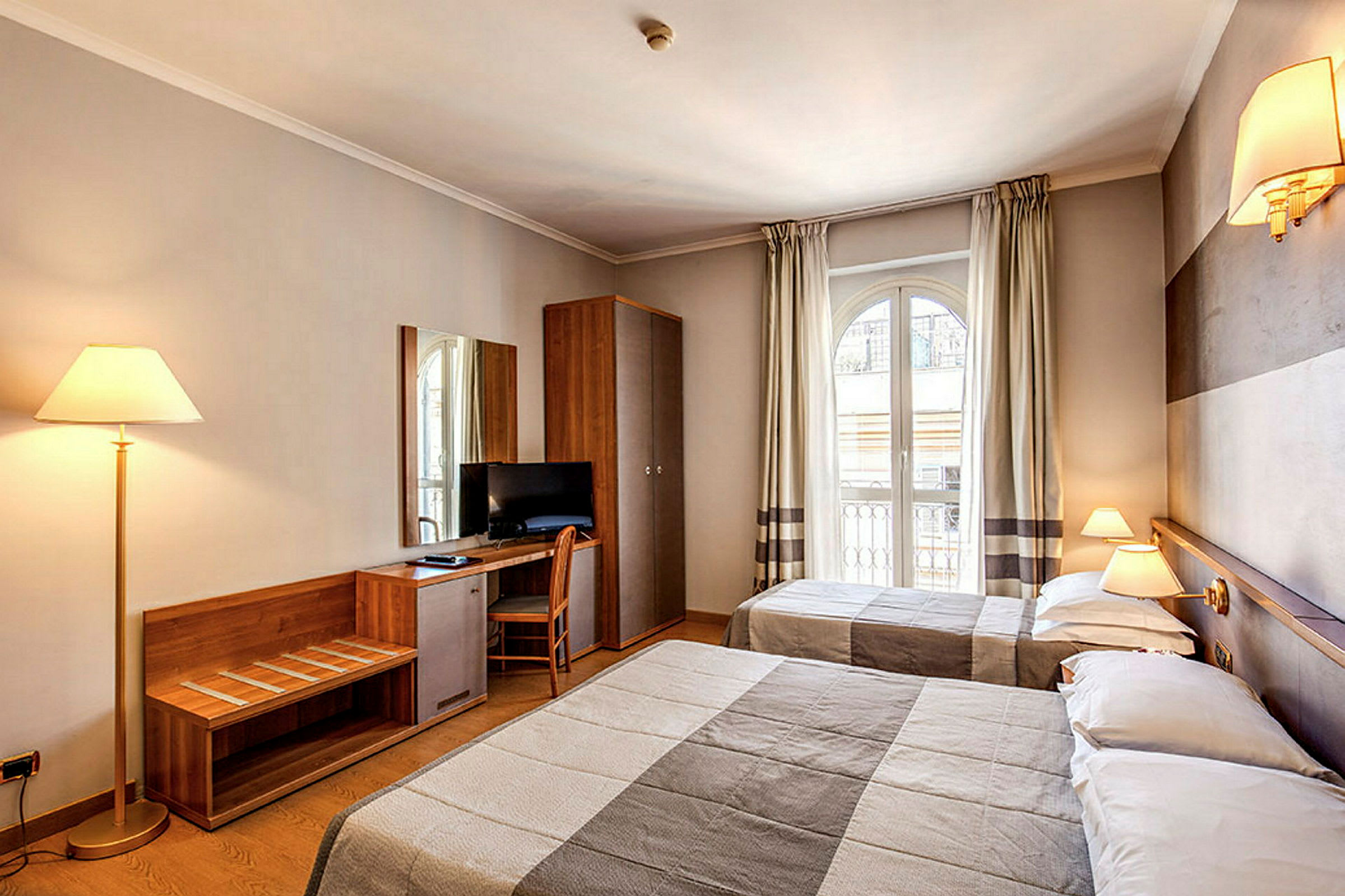 Hotelværelse med to senge, skrivebord med stol, tv og stilfuld indretning. (AI-genereret tekst)