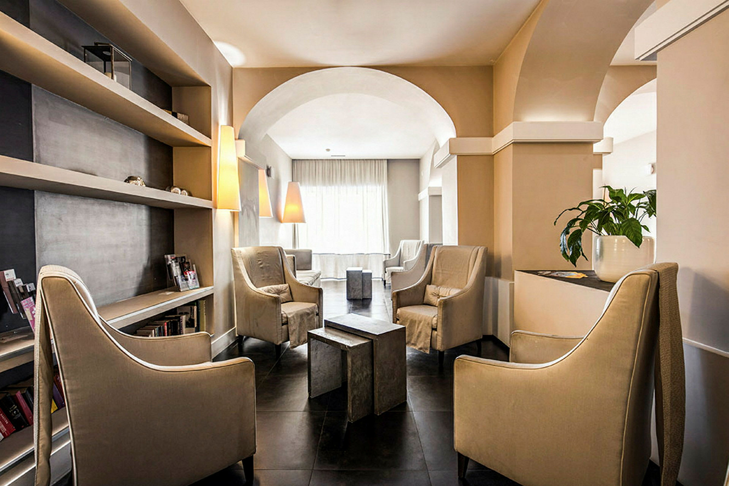 En elegant lounge med store stole, hylder og lamper. (AI-genereret tekst)