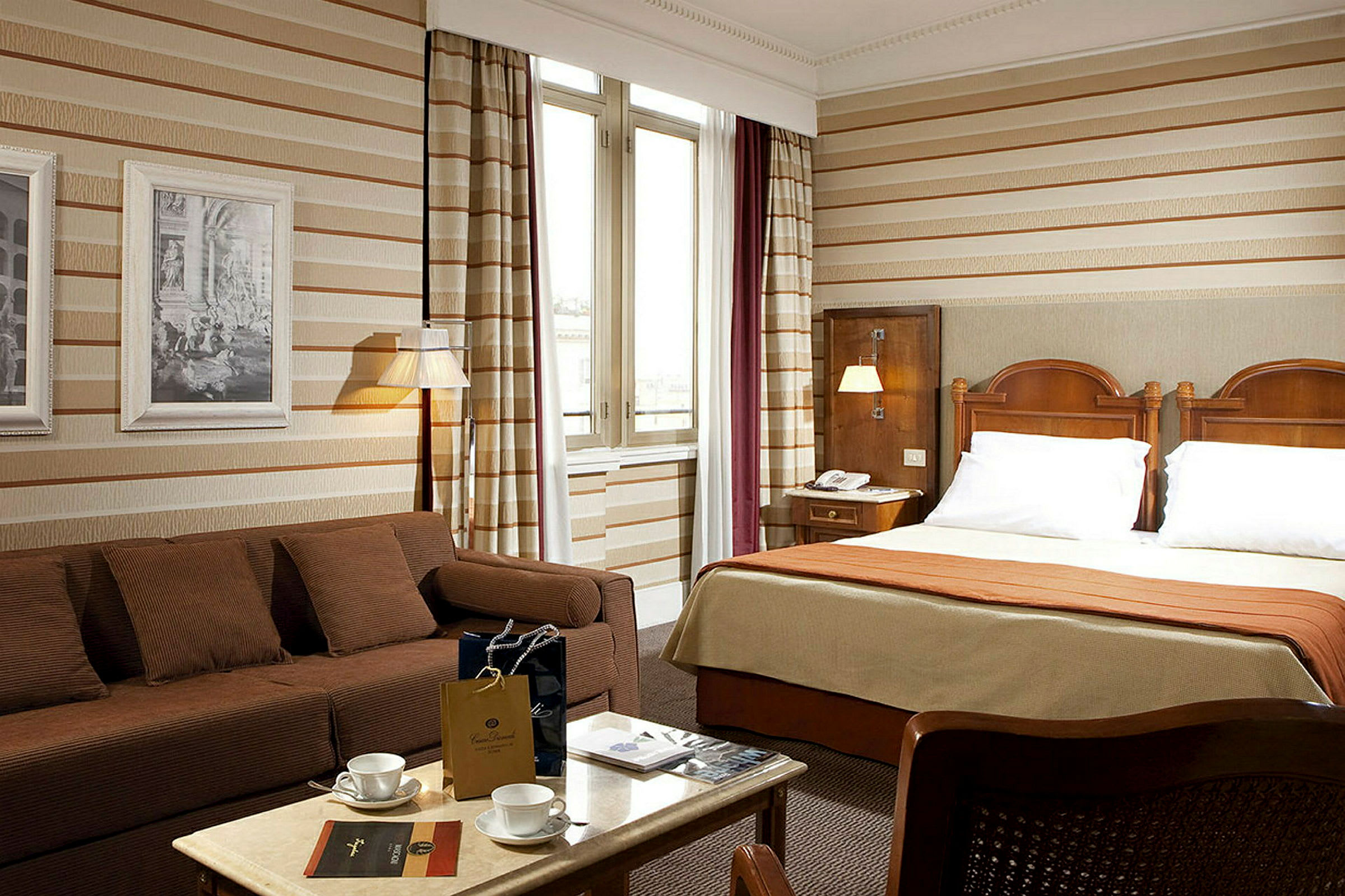 Hotelværelse med dobbeltseng, sofa og bord. (AI-genereret tekst)