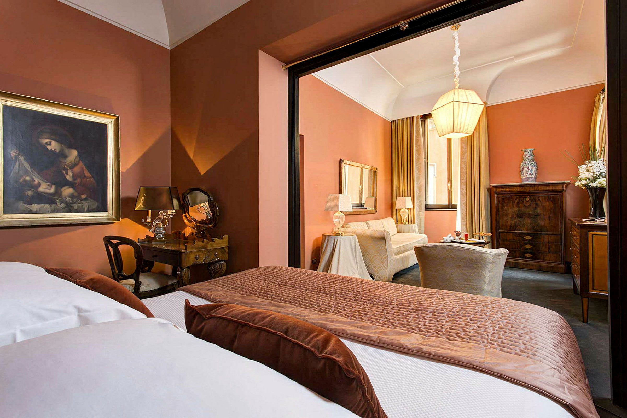 Et elegant hotelværelse med varme orange farver, klassisk indretning og en dobbeltseng i forgrunden. (AI-genereret tekst)
