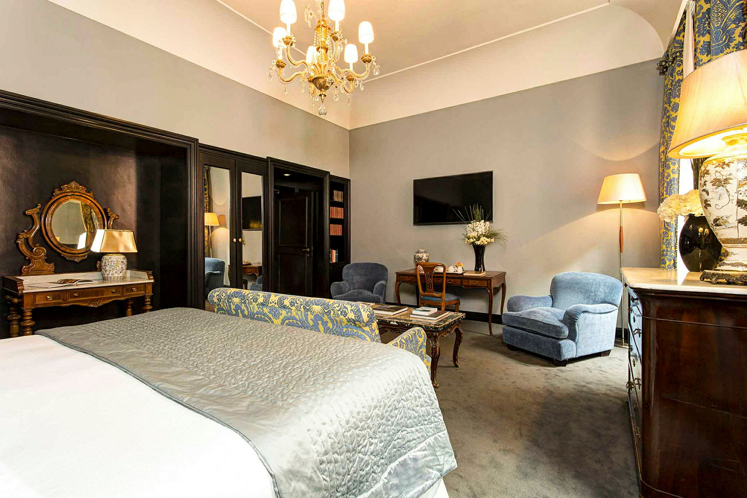 Et velindrettet hotelværelse med en stor seng, siddepladser og elegante indretningsdetaljer. (AI-genereret tekst)